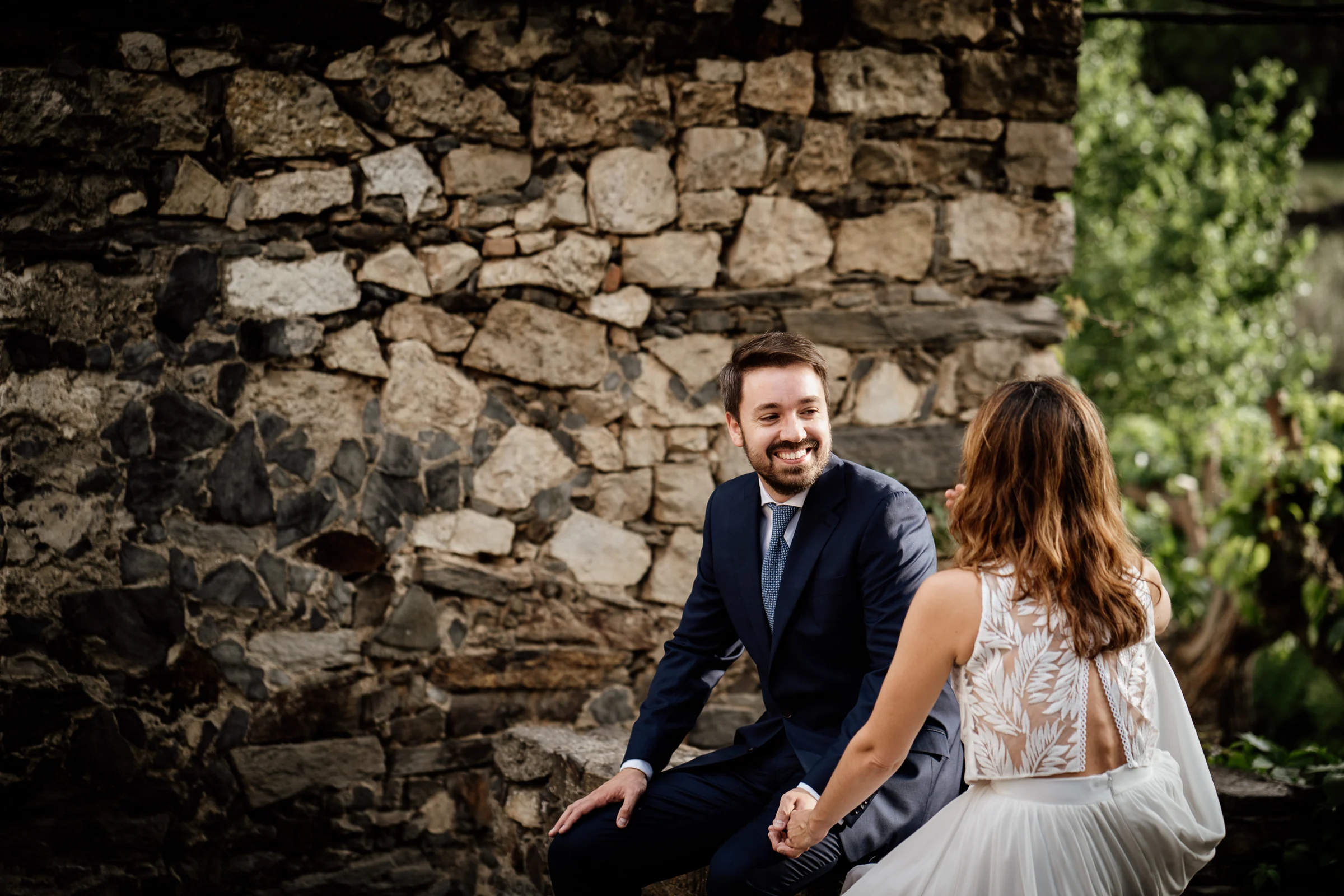 Ainhoa y Fer, momento espontáneo de la pareja sentada entre muros de piedra, Madrid