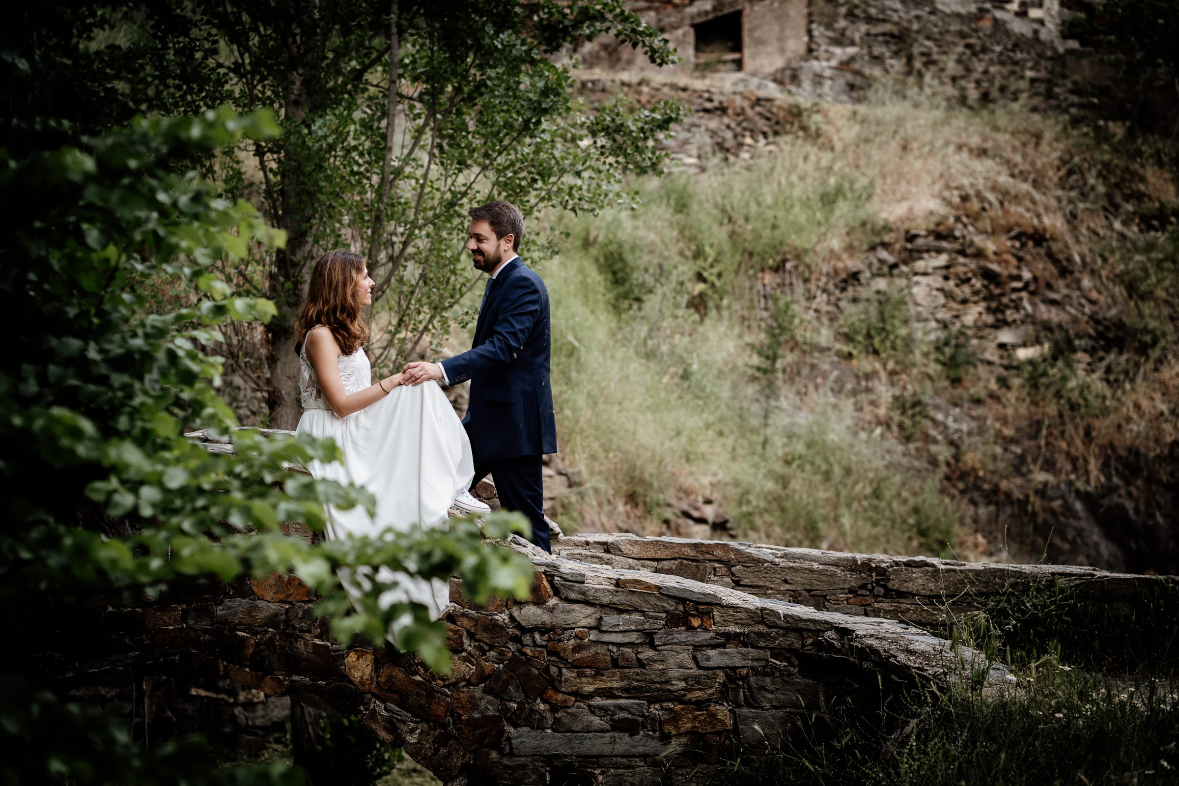 Ainhoa y Fer, retrato de la pareja sobre un puente de piedra en un entorno natural, Madrid