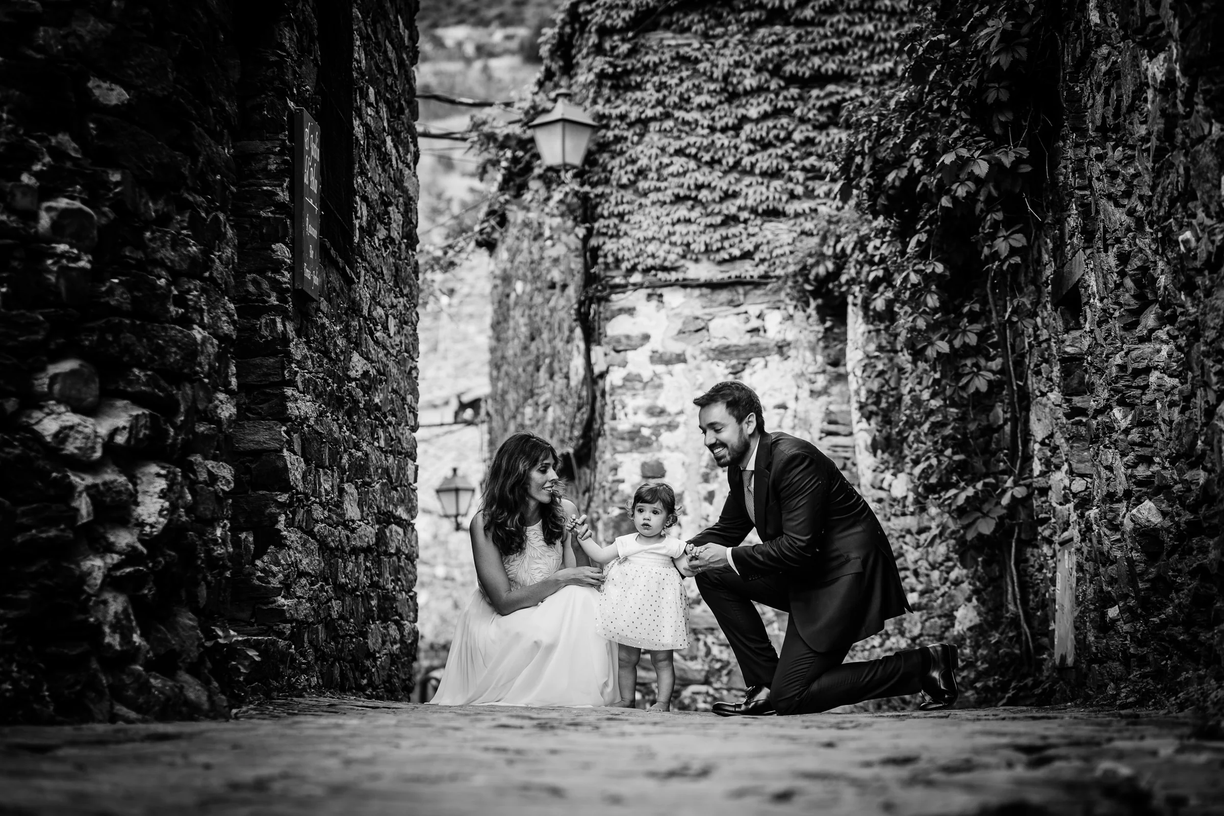 Ainhoa y Fer, retrato familiar en blanco y negro con la niña en una calle de piedra, Madrid