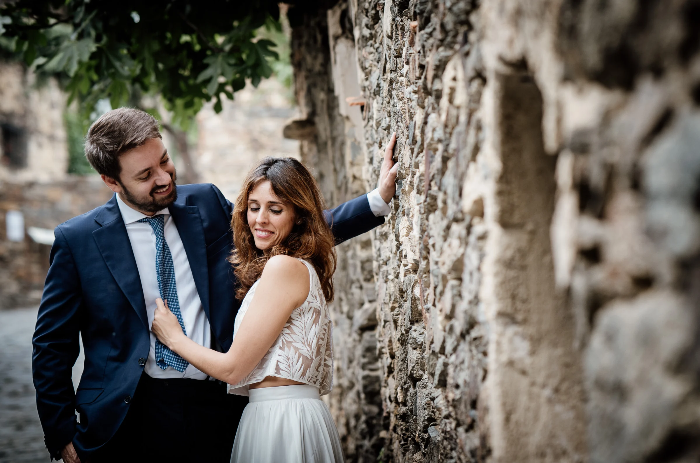Ainhoa y Fer, primer plano de la pareja junto a un muro de piedra, Madrid