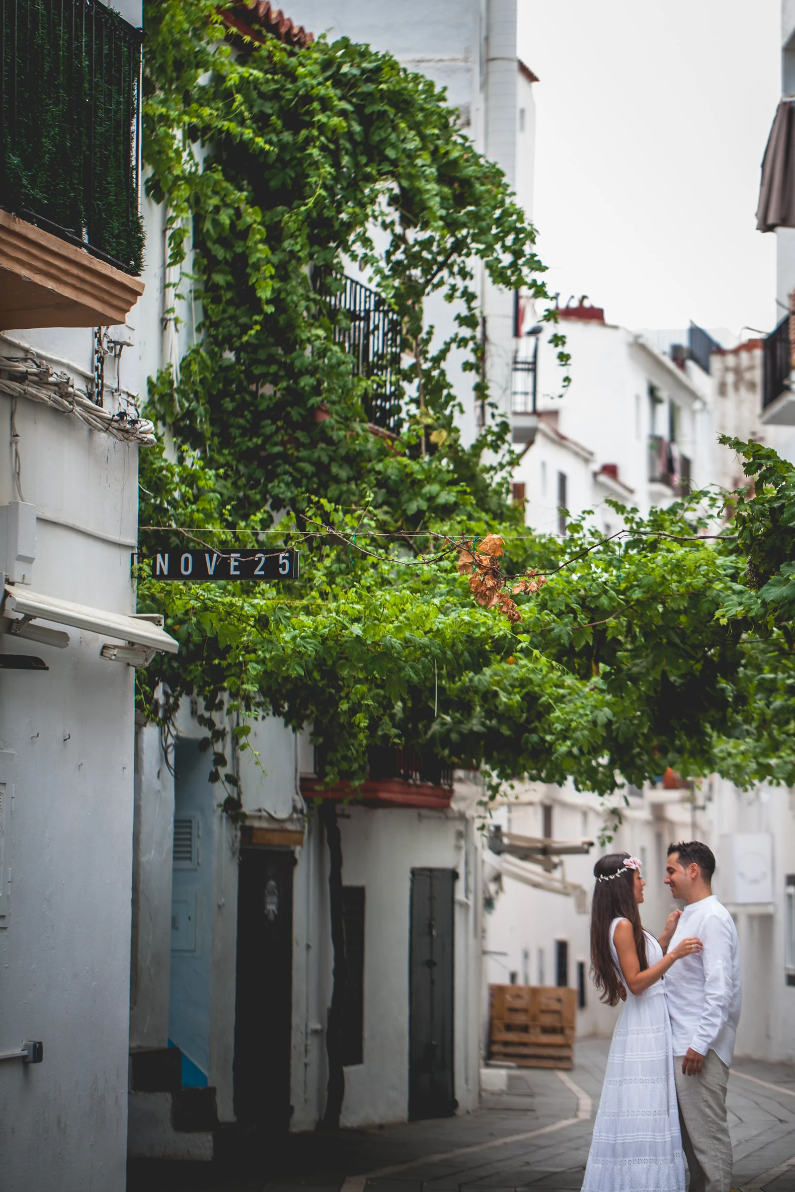 Alba y Jorge caminando por una calle blanca de Ibiza, postboda de Alba y Jorge en Ibiza fotografiada por Pedro Zamorano.