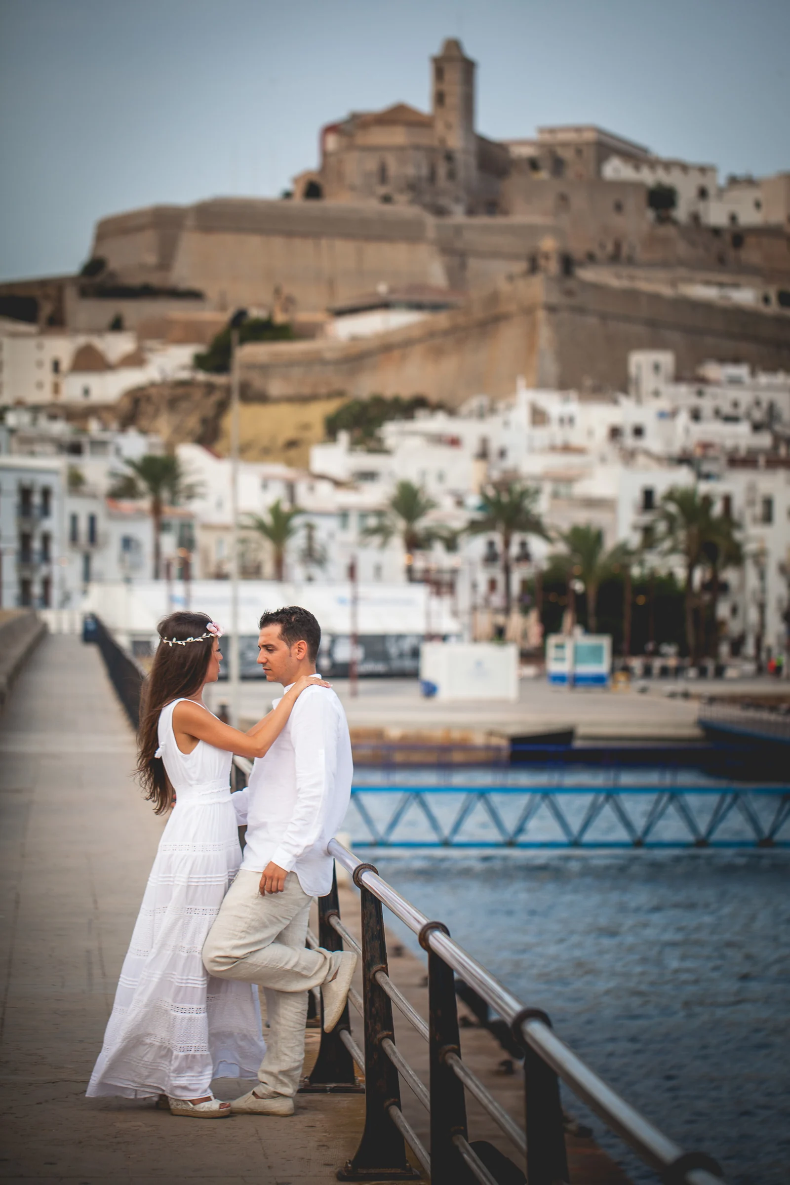 Retrato vertical de la pareja con Dalt Vila al fondo, postboda de Alba y Jorge en Ibiza fotografiada por Pedro Zamorano.