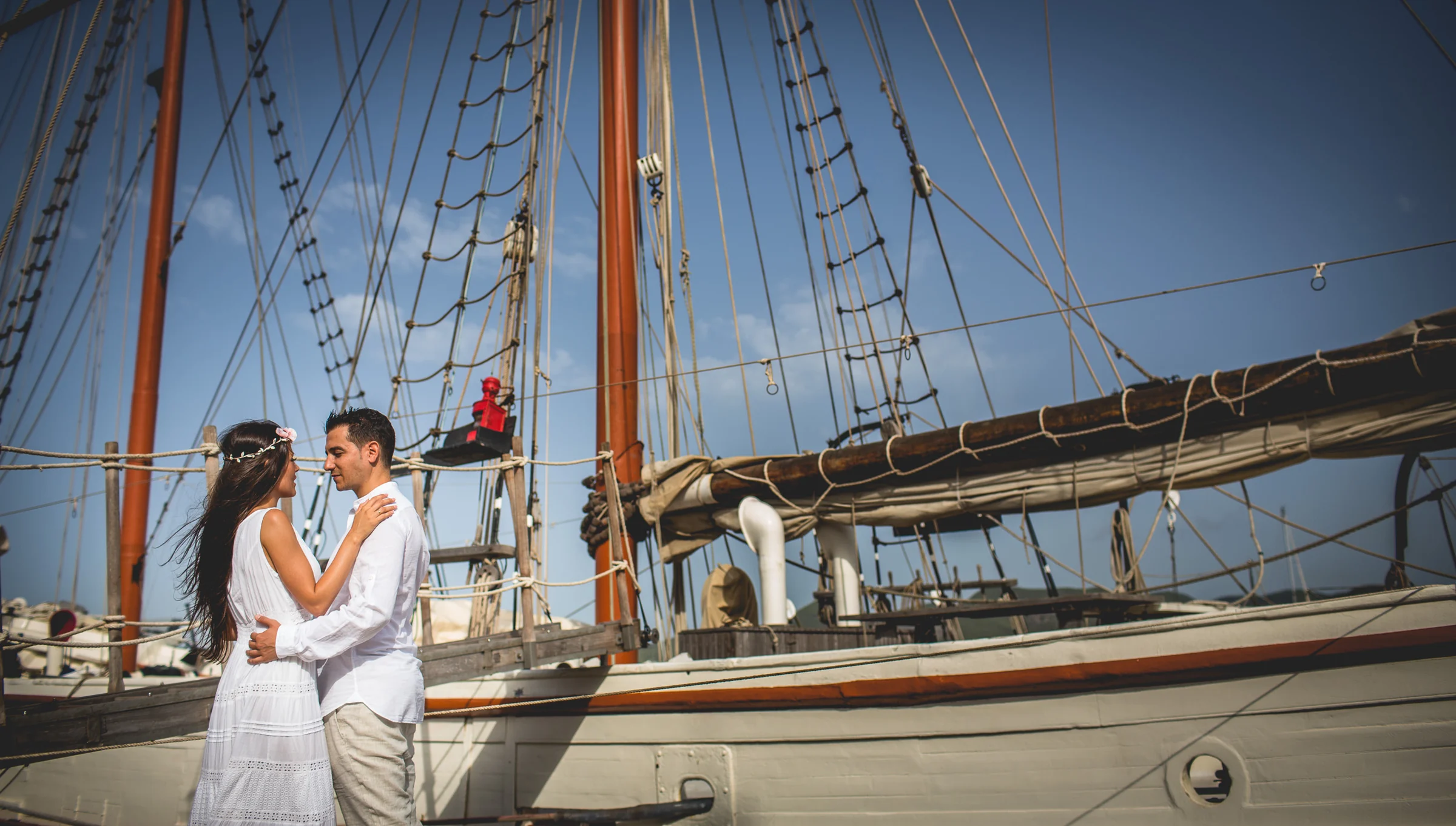Alba y Jorge junto a un velero en el puerto de Ibiza, postboda de Alba y Jorge en Ibiza fotografiada por Pedro Zamorano.
