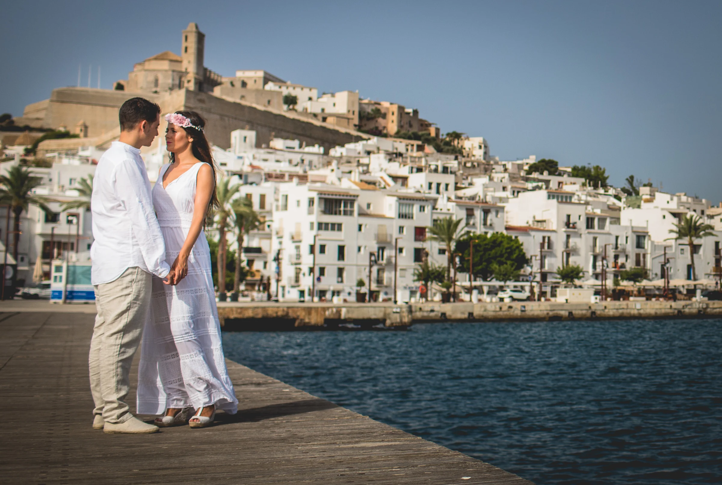 Retrato de pareja con Dalt Vila iluminada por el sol, postboda de Alba y Jorge en Ibiza fotografiada por Pedro Zamorano.