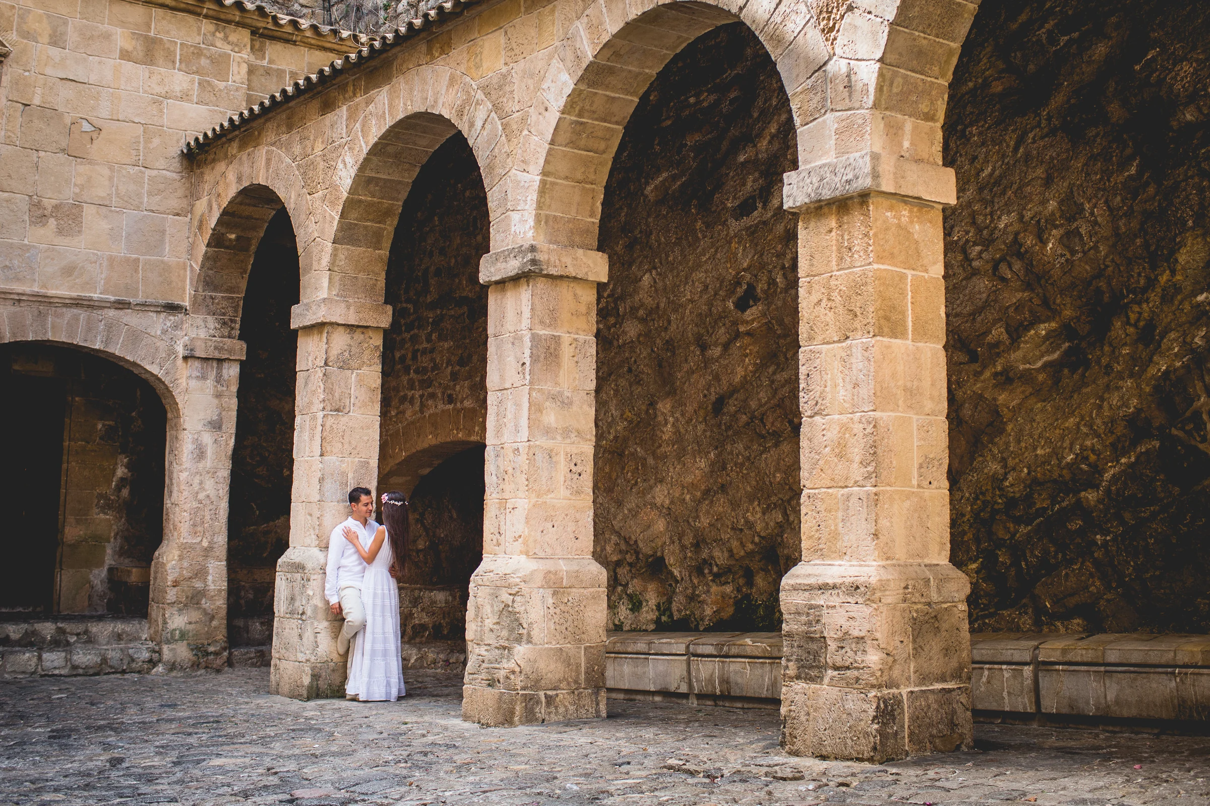 Pareja bajo los arcos de piedra de Dalt Vila, postboda de Alba y Jorge en Ibiza fotografiada por Pedro Zamorano.