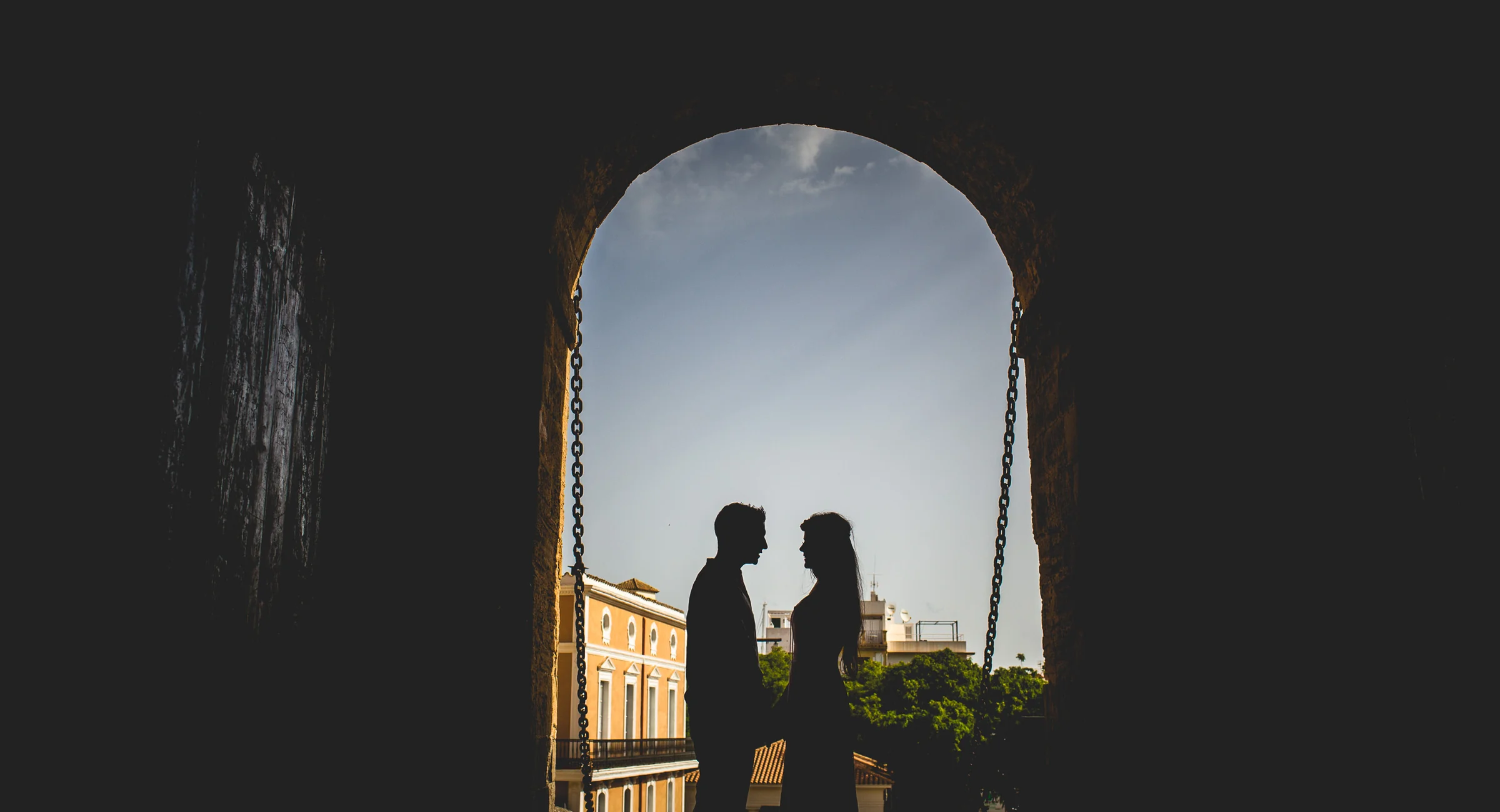 Silueta de Alba y Jorge bajo un arco de Dalt Vila, postboda de Alba y Jorge en Ibiza fotografiada por Pedro Zamorano.