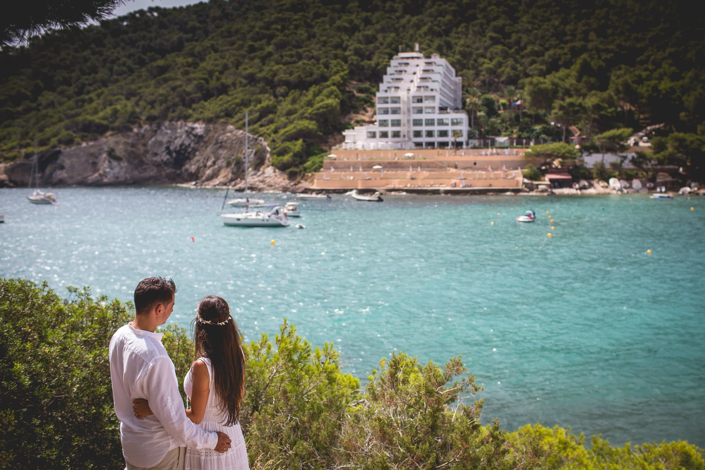 Alba y Jorge contemplando la cala desde un mirador, postboda de Alba y Jorge en Ibiza fotografiada por Pedro Zamorano.