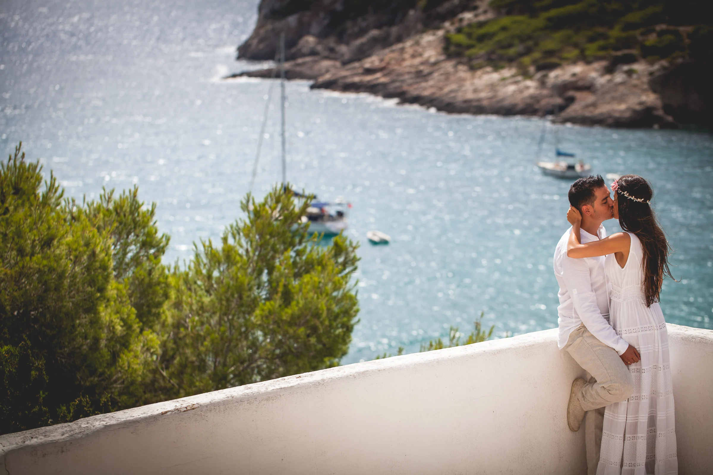 Beso de Alba y Jorge en un mirador sobre la cala, postboda de Alba y Jorge en Ibiza fotografiada por Pedro Zamorano.