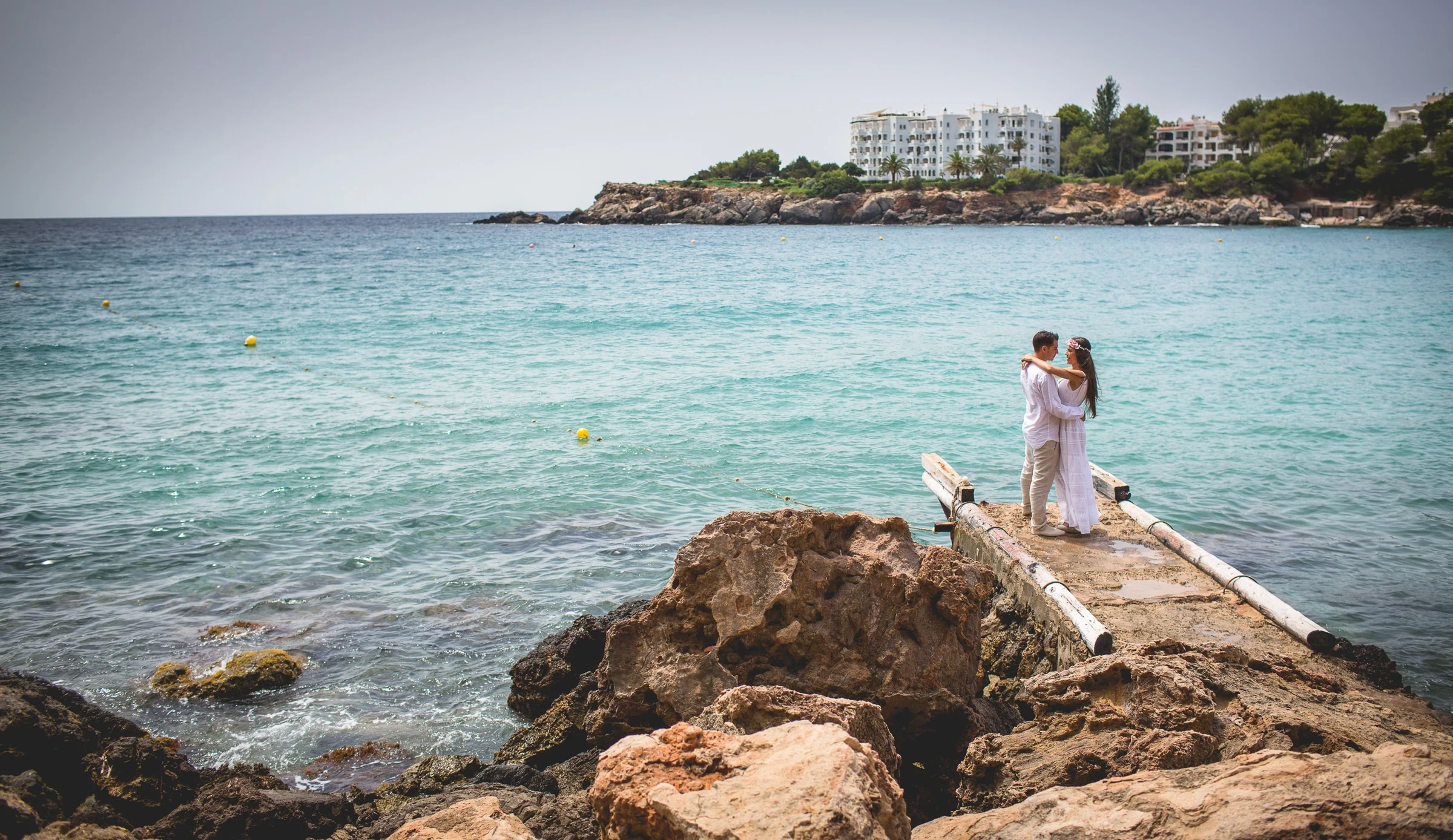 Alba y Jorge en un espigón con el Mediterráneo alrededor, postboda de Alba y Jorge en Ibiza fotografiada por Pedro Zamorano.