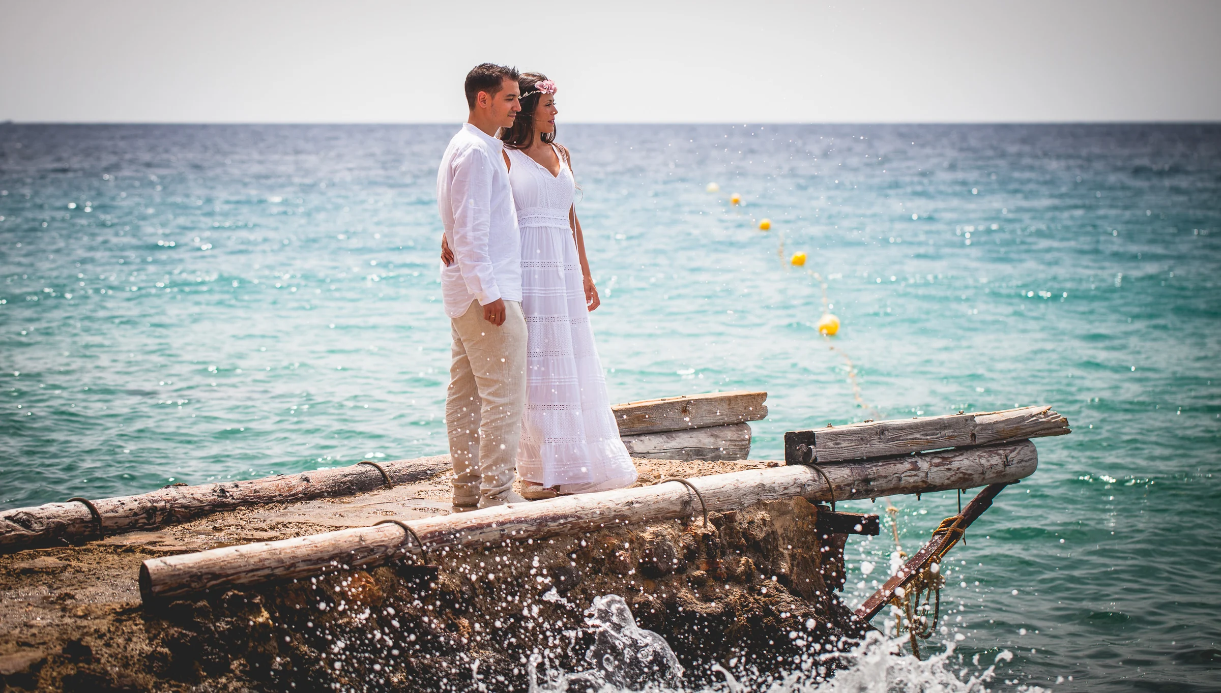 Pareja frente al mar con salpicaduras de olas, postboda de Alba y Jorge en Ibiza fotografiada por Pedro Zamorano.