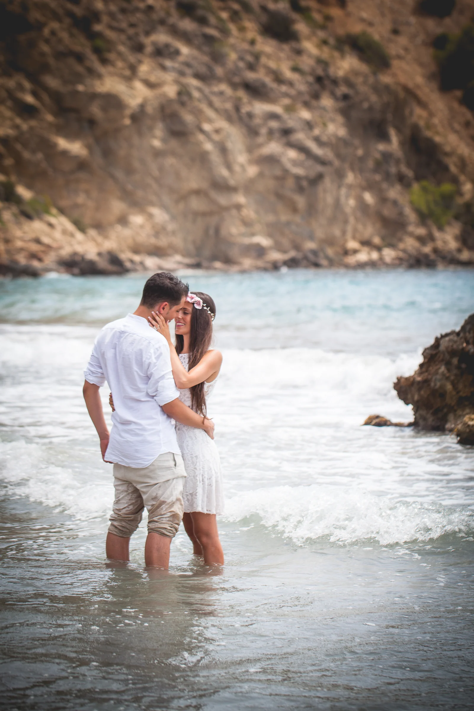 Retrato vertical de la pareja abrazada dentro del mar, postboda de Alba y Jorge en Ibiza fotografiada por Pedro Zamorano.