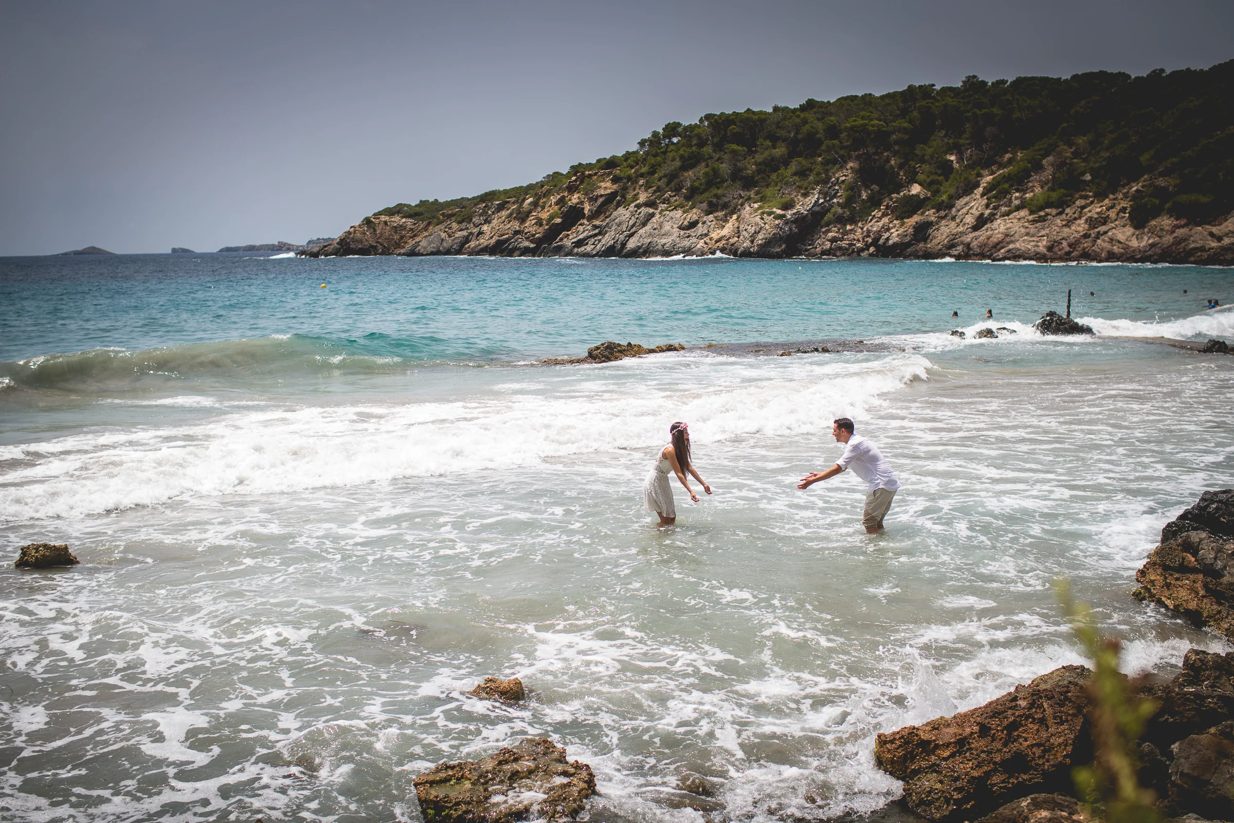 Alba y Jorge jugando dentro del agua, postboda de Alba y Jorge en Ibiza fotografiada por Pedro Zamorano.