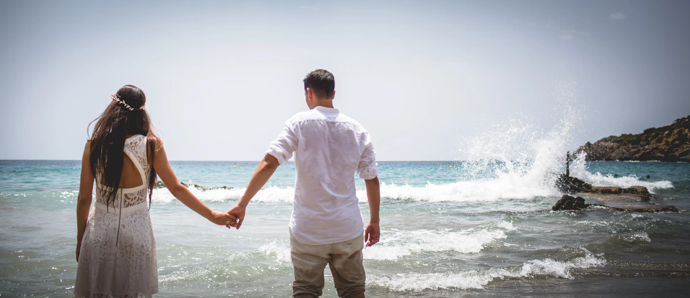 Alba y Jorge caminando de la mano hacia el mar, postboda de Alba y Jorge en Ibiza fotografiada por Pedro Zamorano.