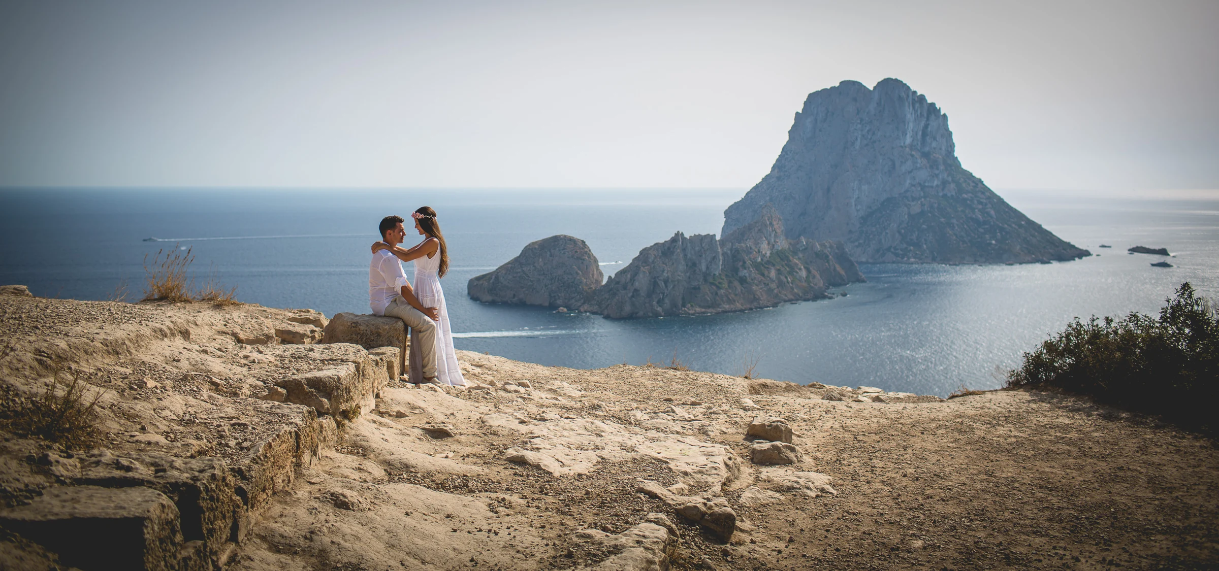 Alba y Jorge en paisaje abierto con Es Vedrà al fondo, postboda de Alba y Jorge en Ibiza fotografiada por Pedro Zamorano.