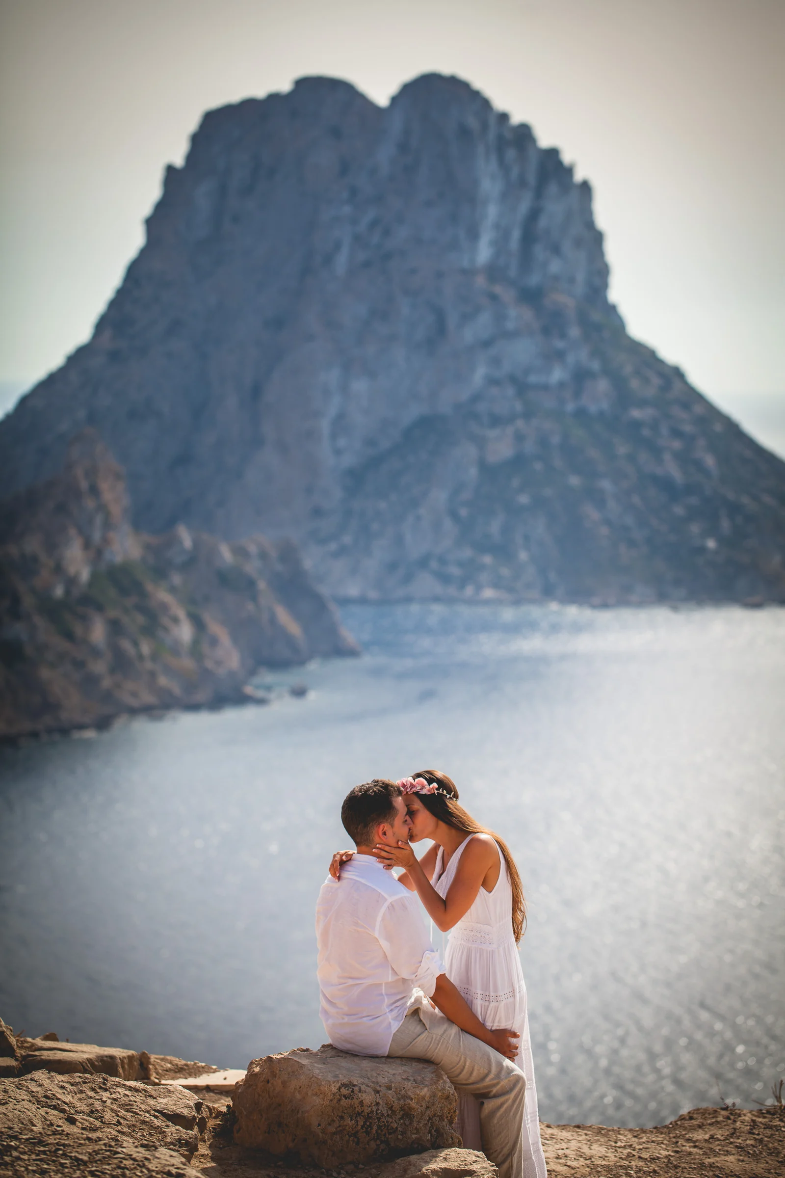 Beso de la pareja ante Es Vedrà en formato vertical, postboda de Alba y Jorge en Ibiza fotografiada por Pedro Zamorano.
