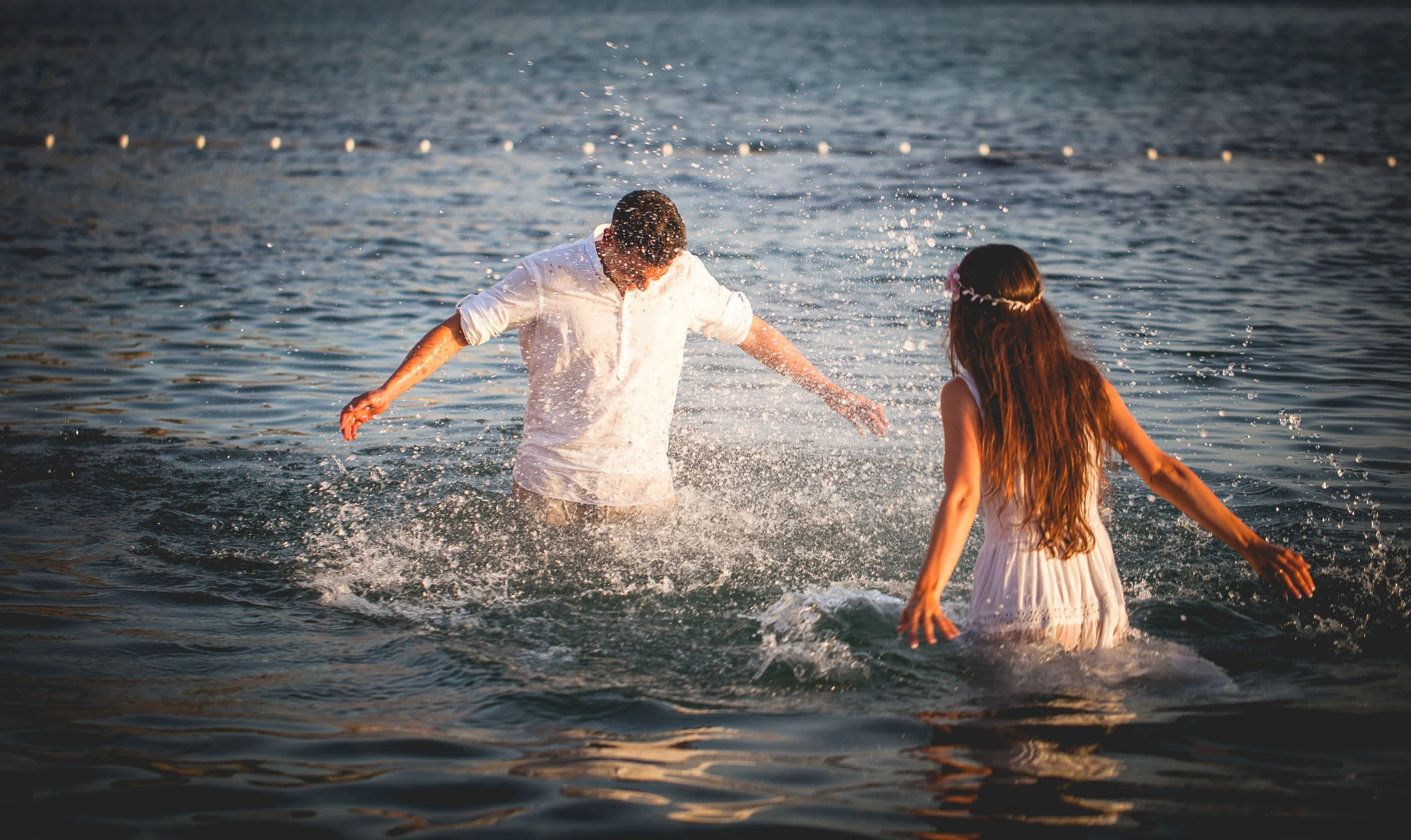 Alba y Jorge jugando con el agua al atardecer, postboda de Alba y Jorge en Ibiza fotografiada por Pedro Zamorano.