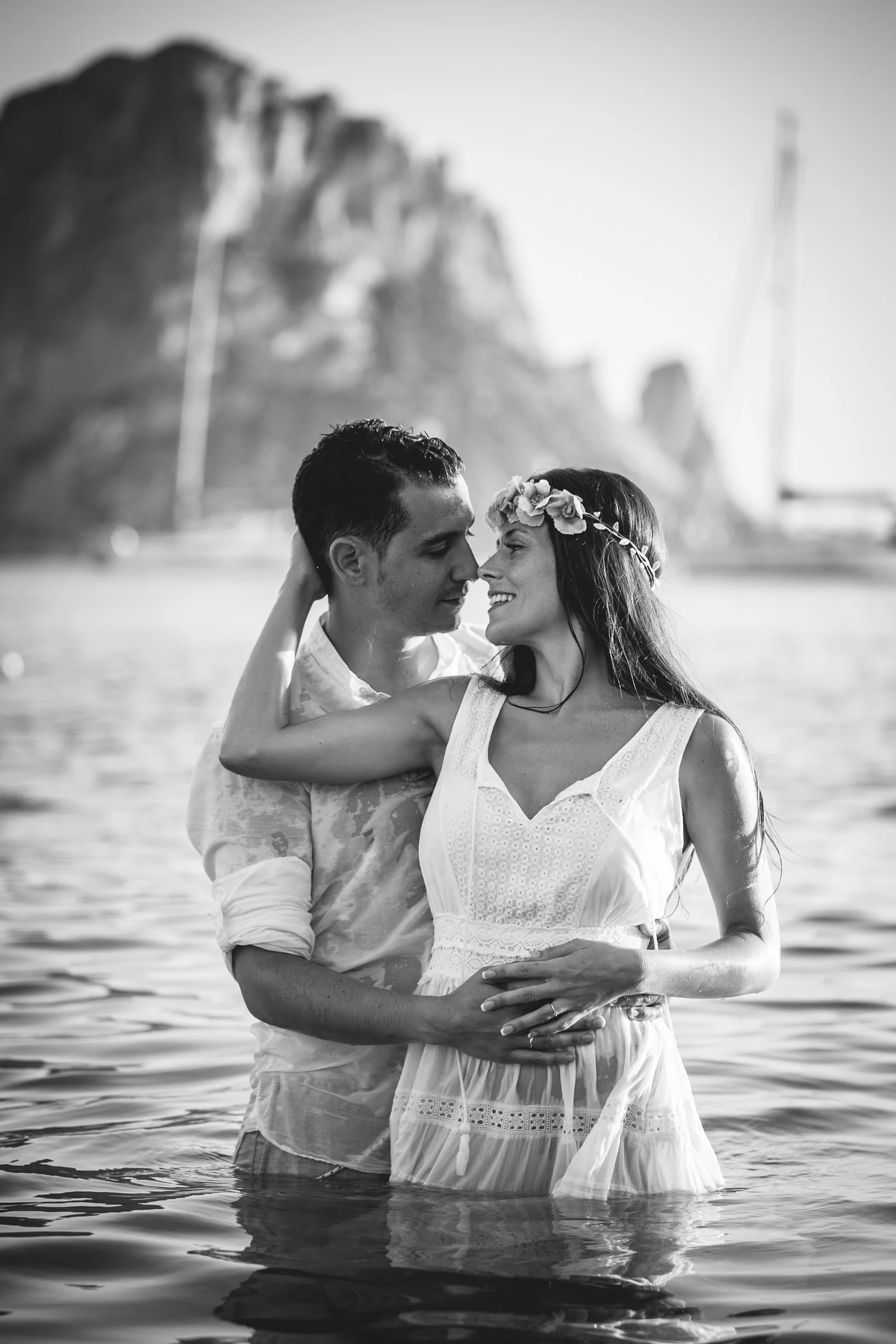 Retrato vertical en blanco y negro de Alba y Jorge dentro del agua, postboda de Alba y Jorge en Ibiza fotografiada por Pedro Zamorano.