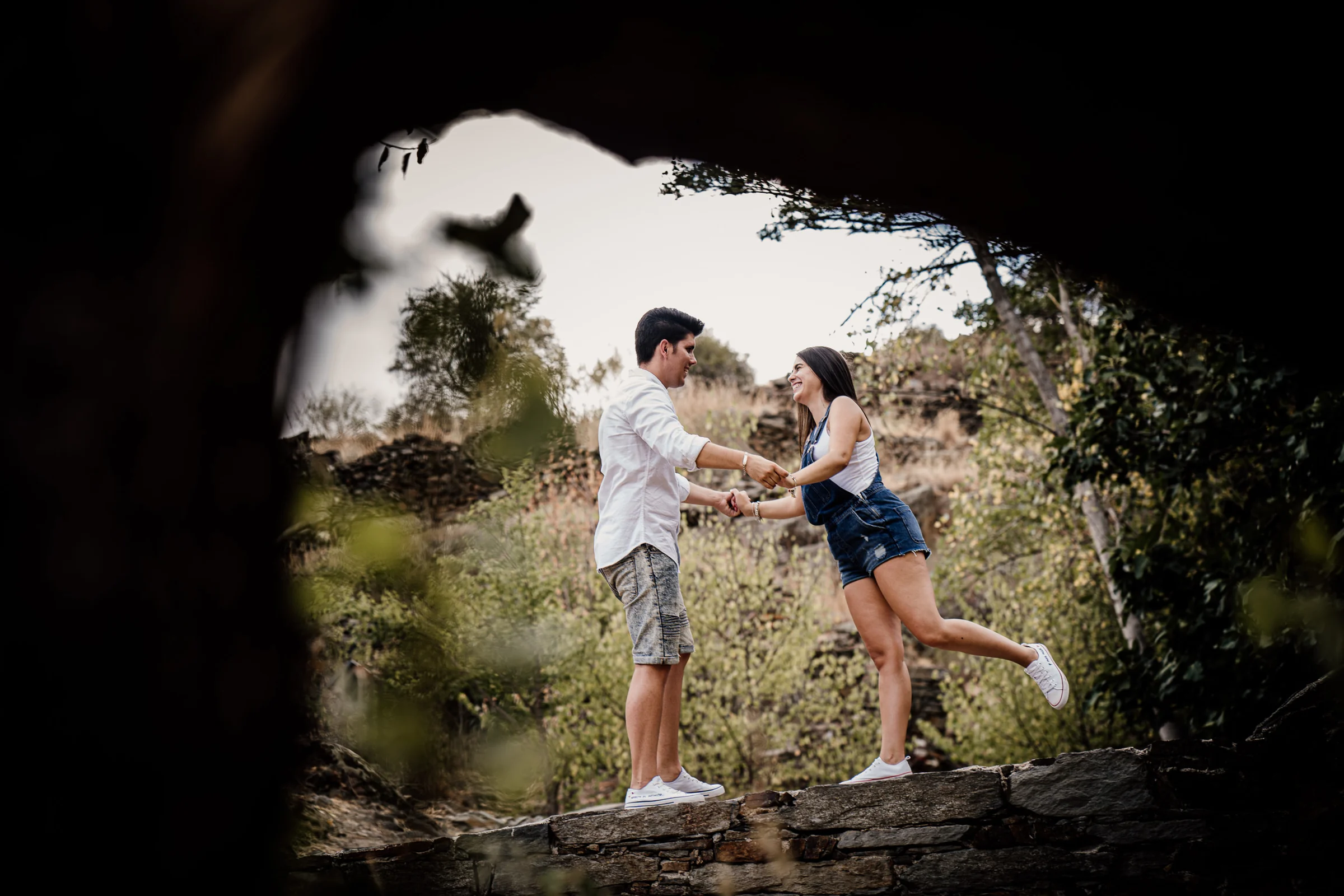 Aritz y Laura juegan cogidos de las manos en un rincón rural de Patones durante su sesión de preboda.