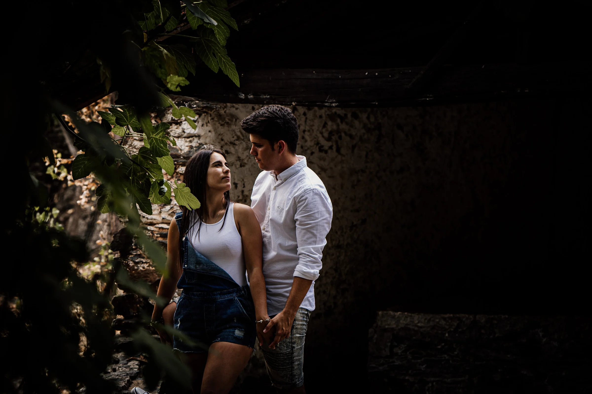 Aritz y Laura se miran de cerca entre sombras y vegetación durante su preboda en Patones.