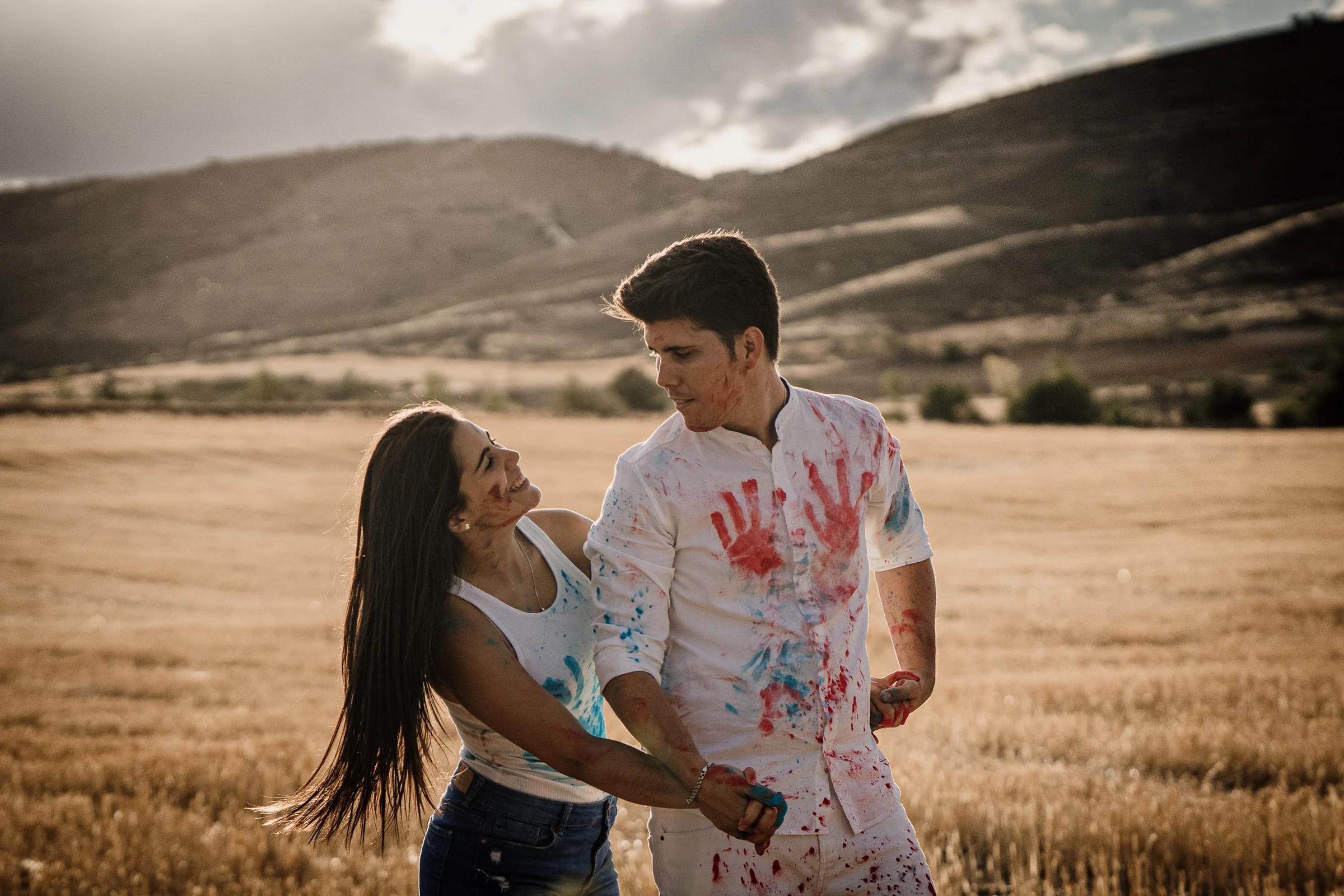 Laura sonríe junto a Aritz mientras las huellas de pintura cubren su ropa durante la preboda en Patones.