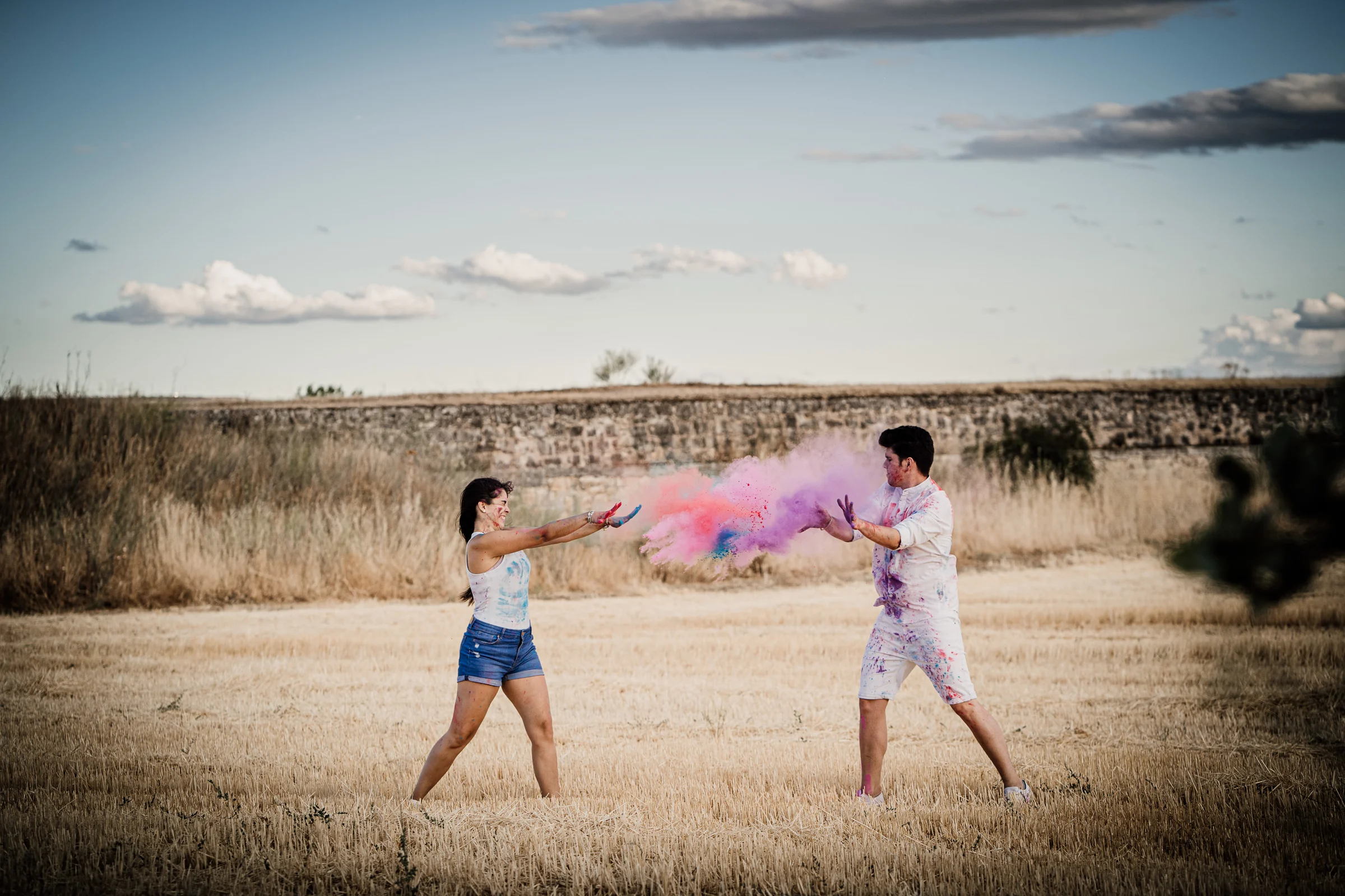 Aritz y Laura lanzan polvos de colores entre ellos en un campo durante su preboda en Patones.