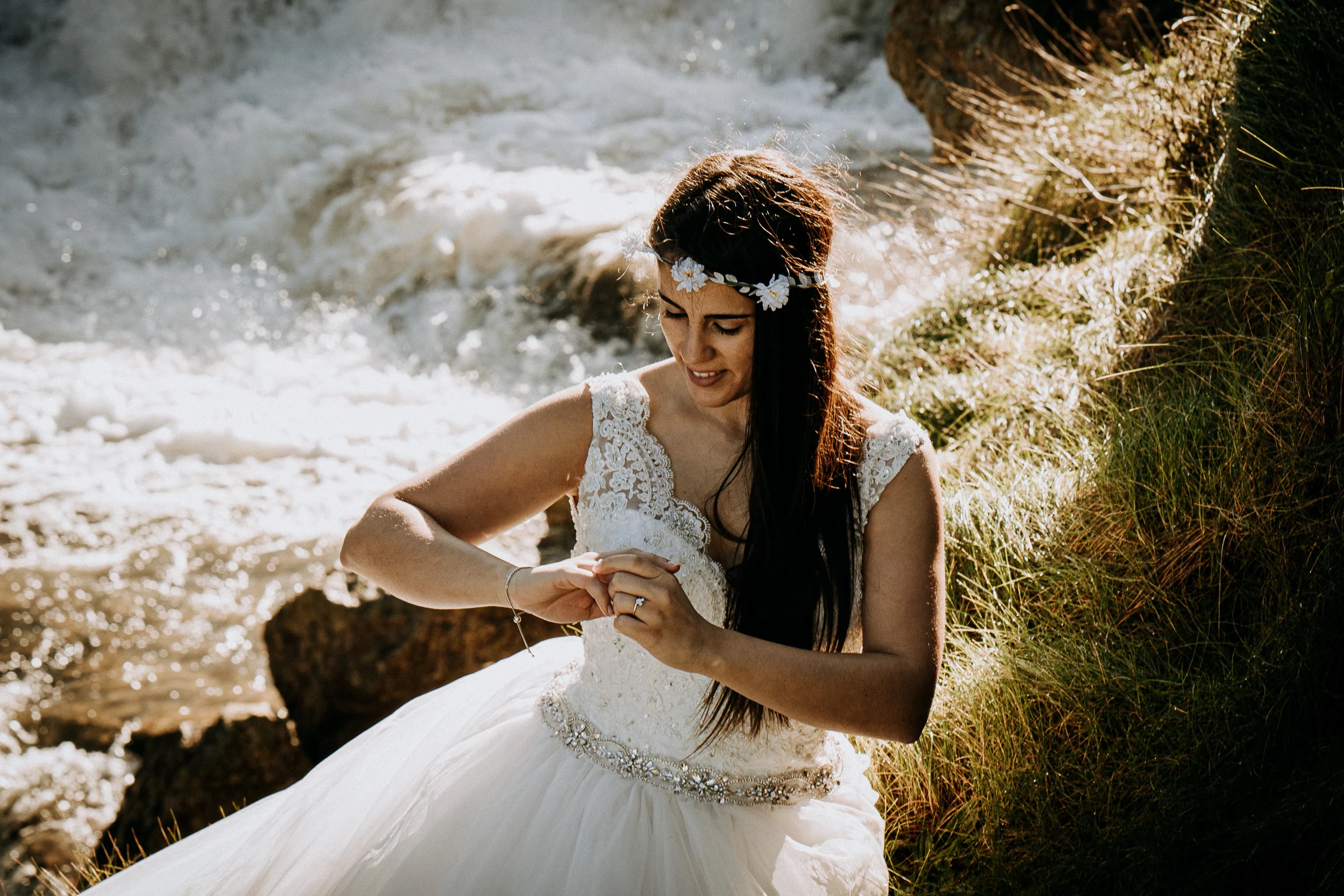 Detalle natural de la novia junto al agua durante una sesión de postboda en El Molino, cerca de Llanes, Asturias.