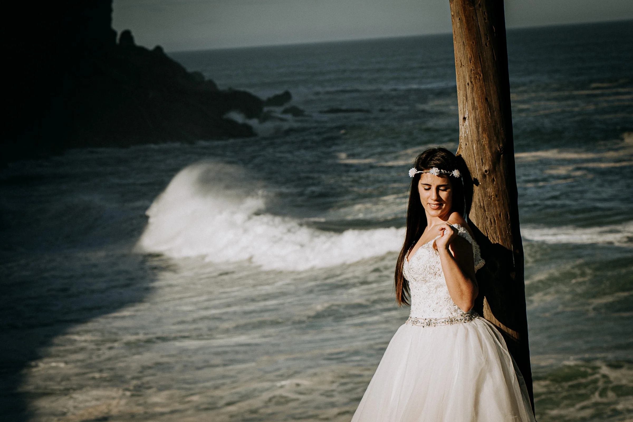Novia junto al mar y una antigua estructura costera durante una sesión de postboda en El Molino, cerca de Llanes, Asturias.