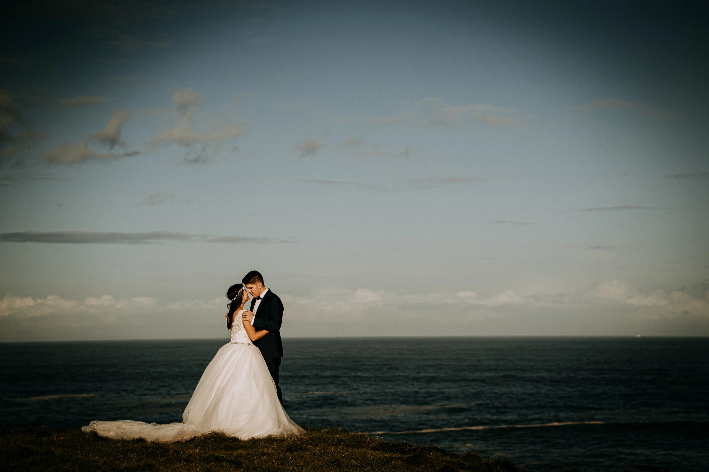Pareja abrazada frente al mar en un encuadre minimalista durante una sesión de postboda en El Molino, cerca de Llanes, Asturias.