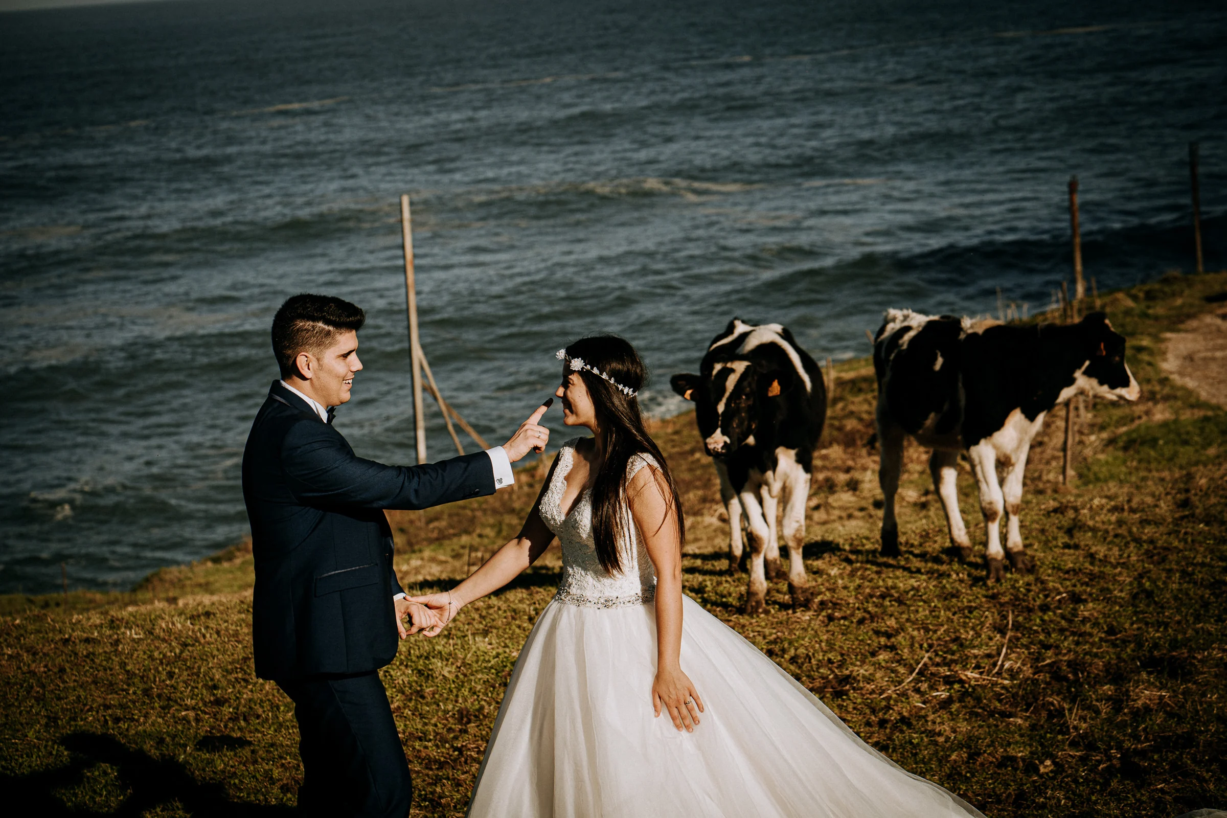Pareja en un paisaje rural costero durante la postboda durante una sesión de postboda en El Molino, cerca de Llanes, Asturias.
