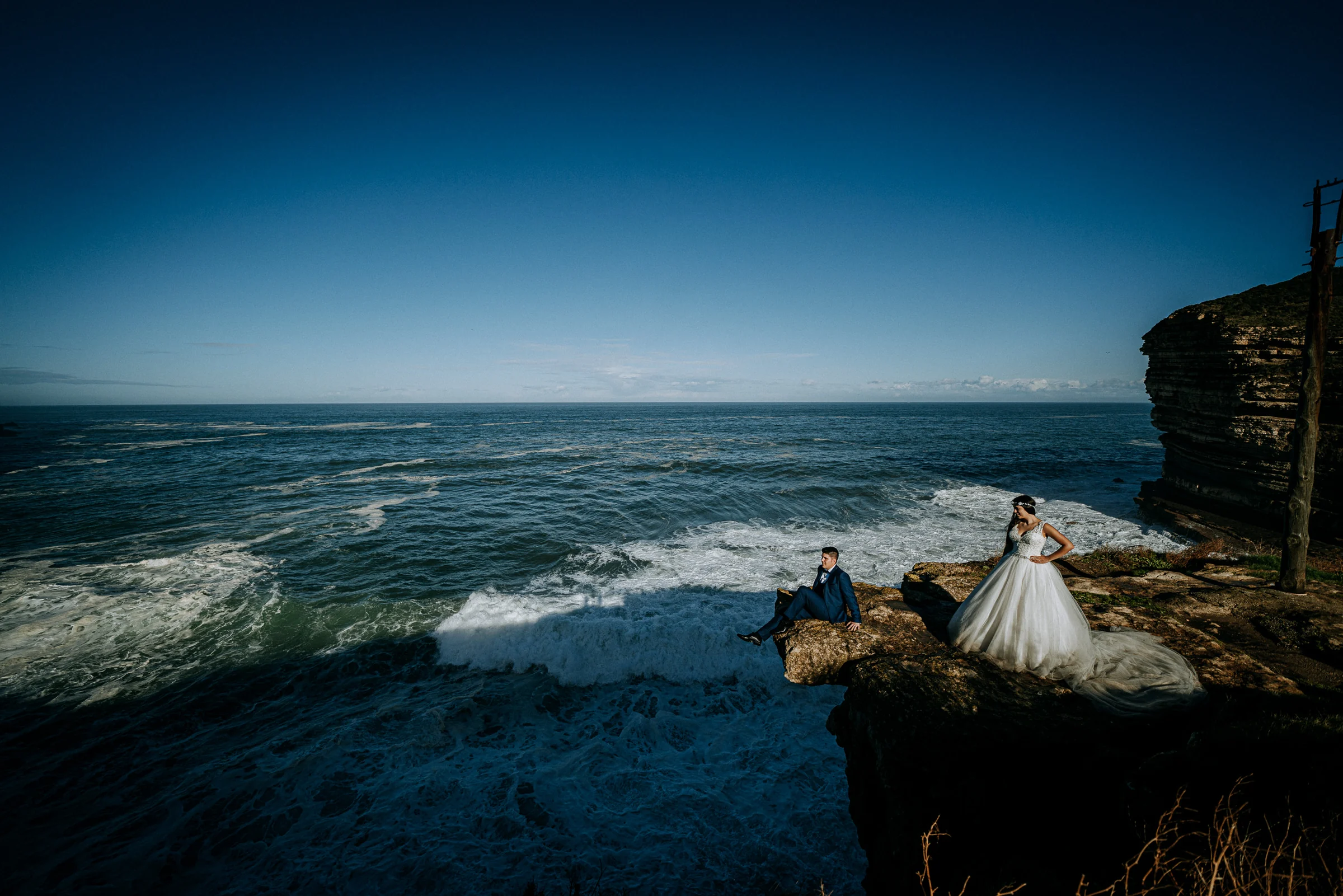 Pareja sobre un acantilado con mar abierto durante una sesión de postboda en El Molino, cerca de Llanes, Asturias.