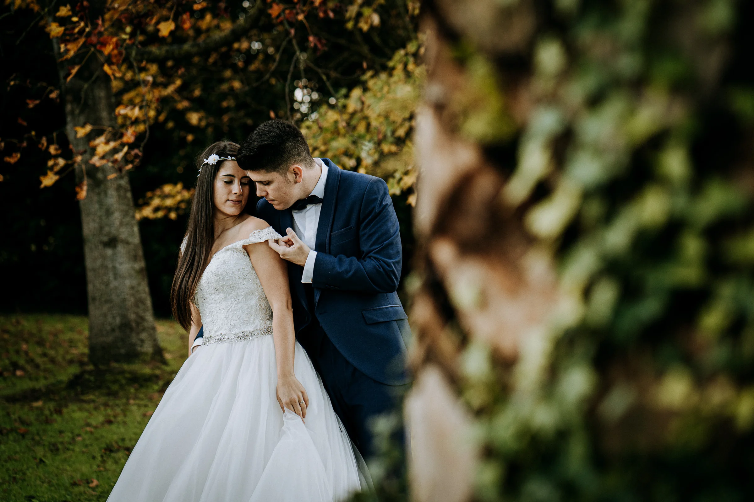 Retrato íntimo de la pareja en un jardín otoñal durante una sesión de postboda en El Molino, cerca de Llanes, Asturias.