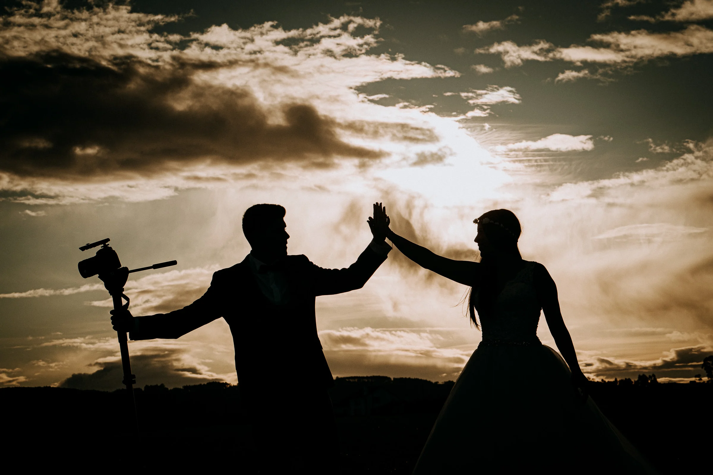 Silueta creativa de la pareja junto a una cámara de vídeo durante una sesión de postboda en El Molino, cerca de Llanes, Asturias.