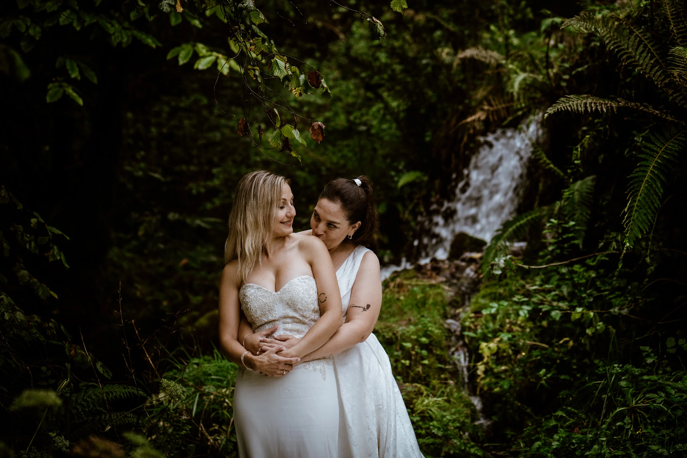 Abrazo de Carmen y Vanesa junto a una cascada