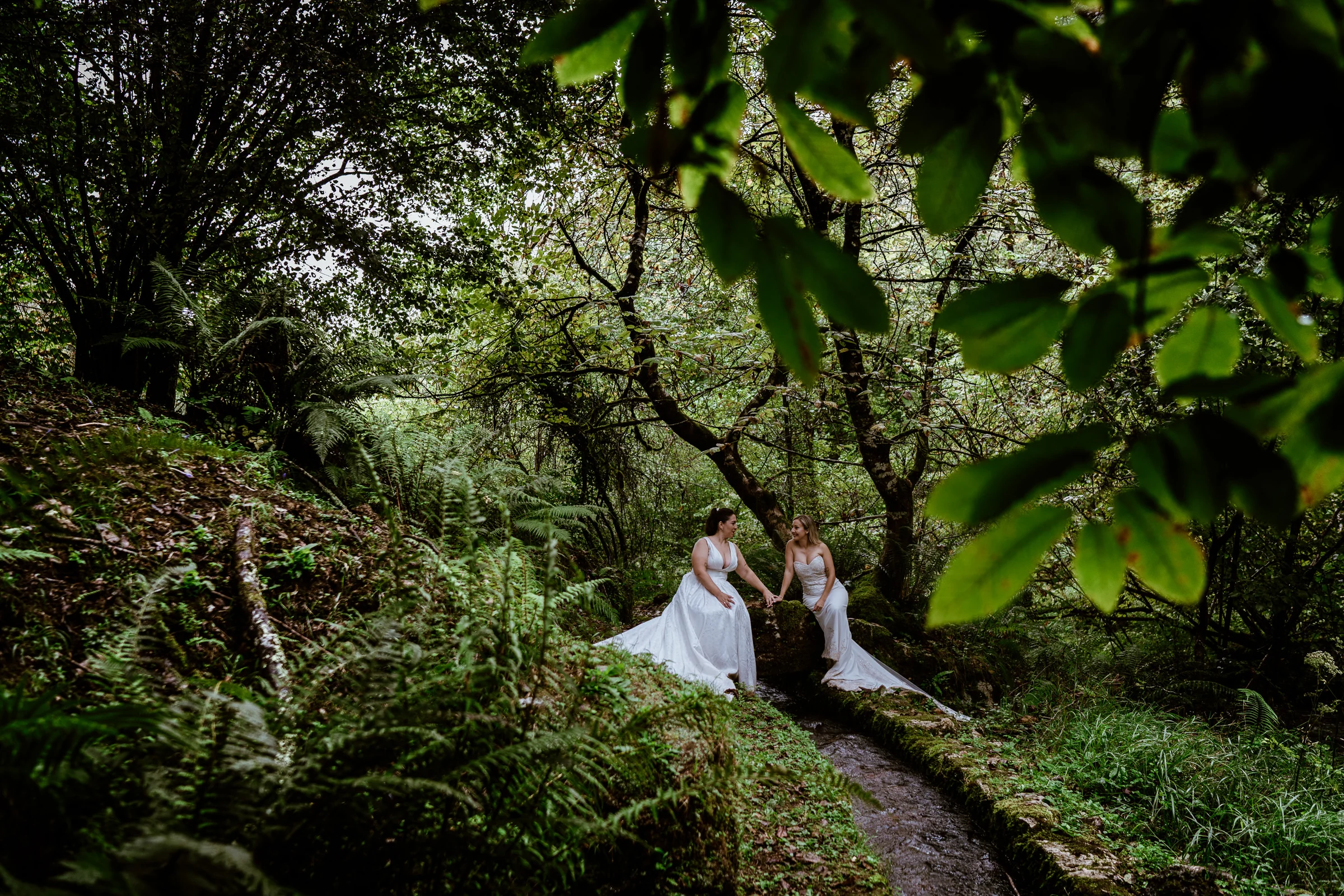 Carmen y Vanesa junto a un canal de agua en el bosque