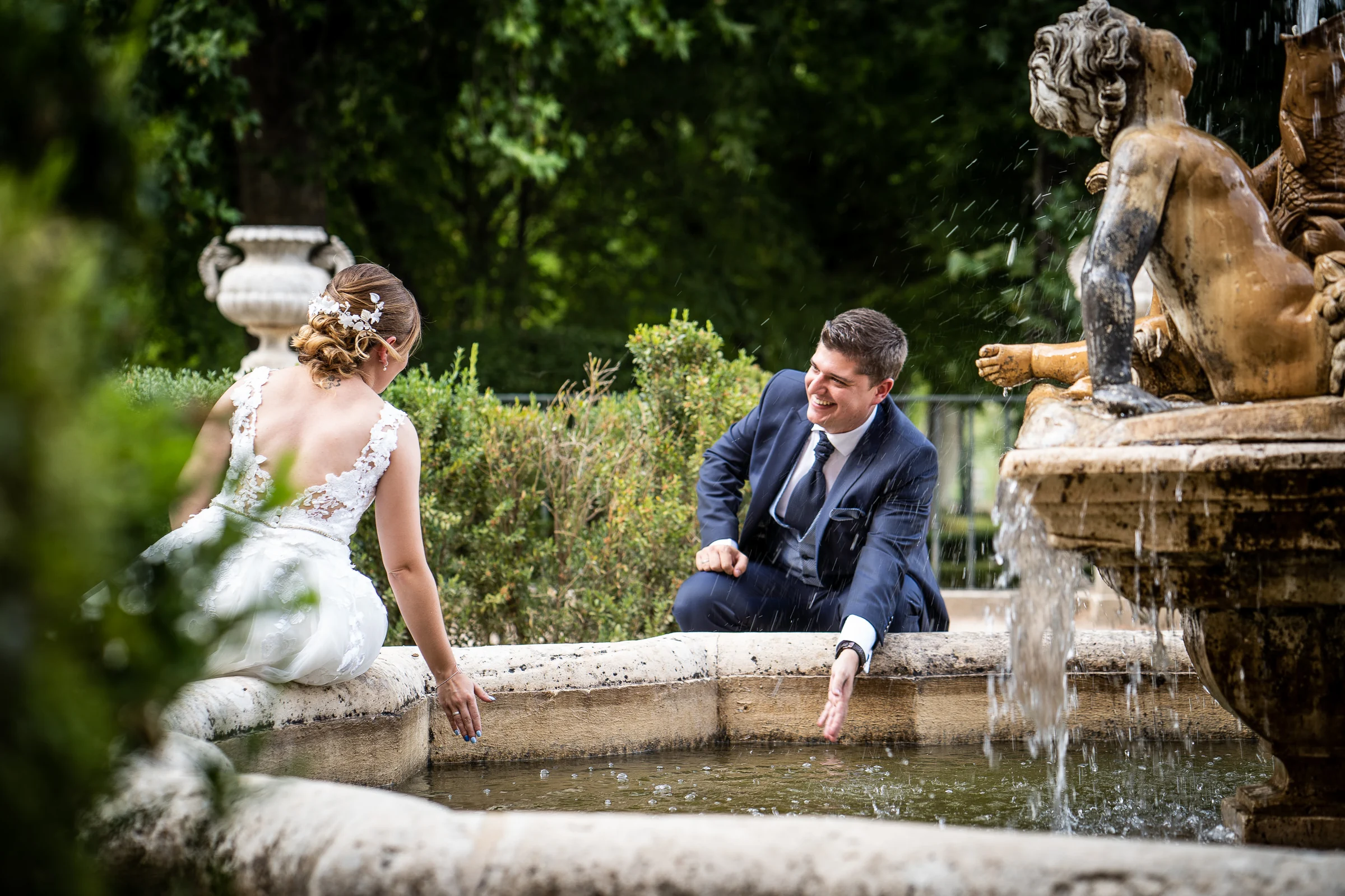 Dani y Nerea riendo junto a una fuente en los jardines de Aranjuez