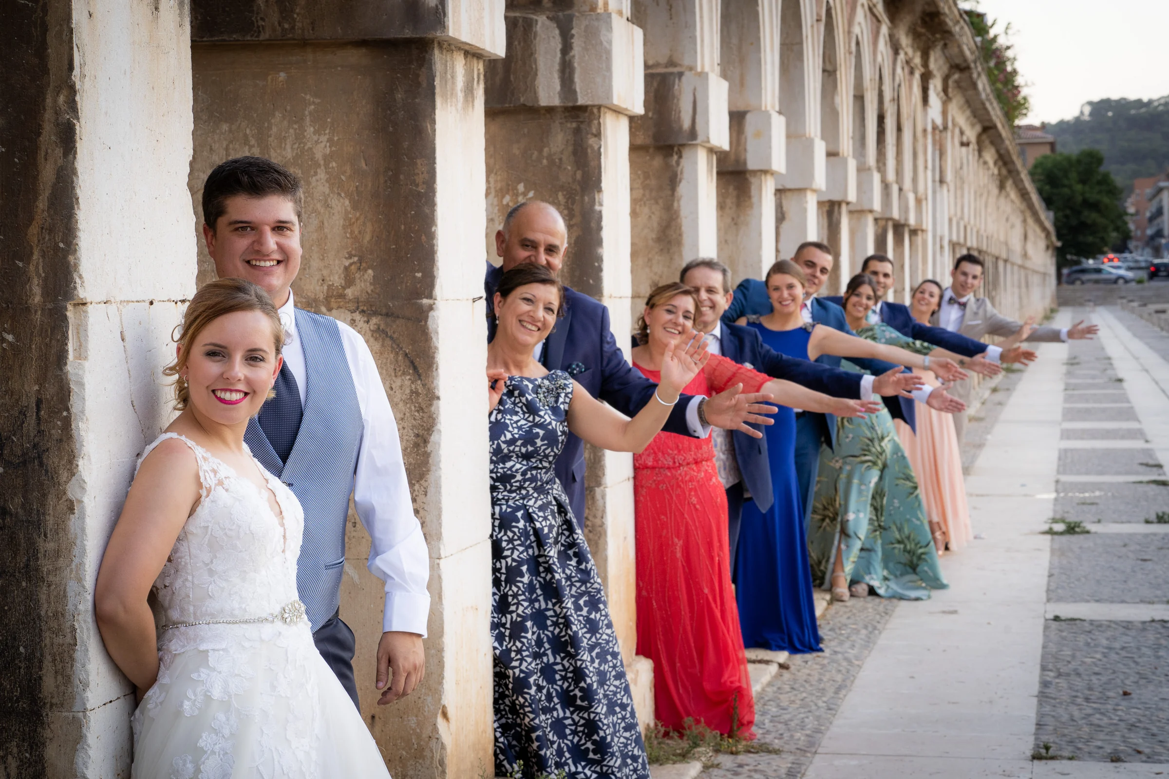 Dani y Nerea con familiares y amigos saludando entre columnas en Aranjuez