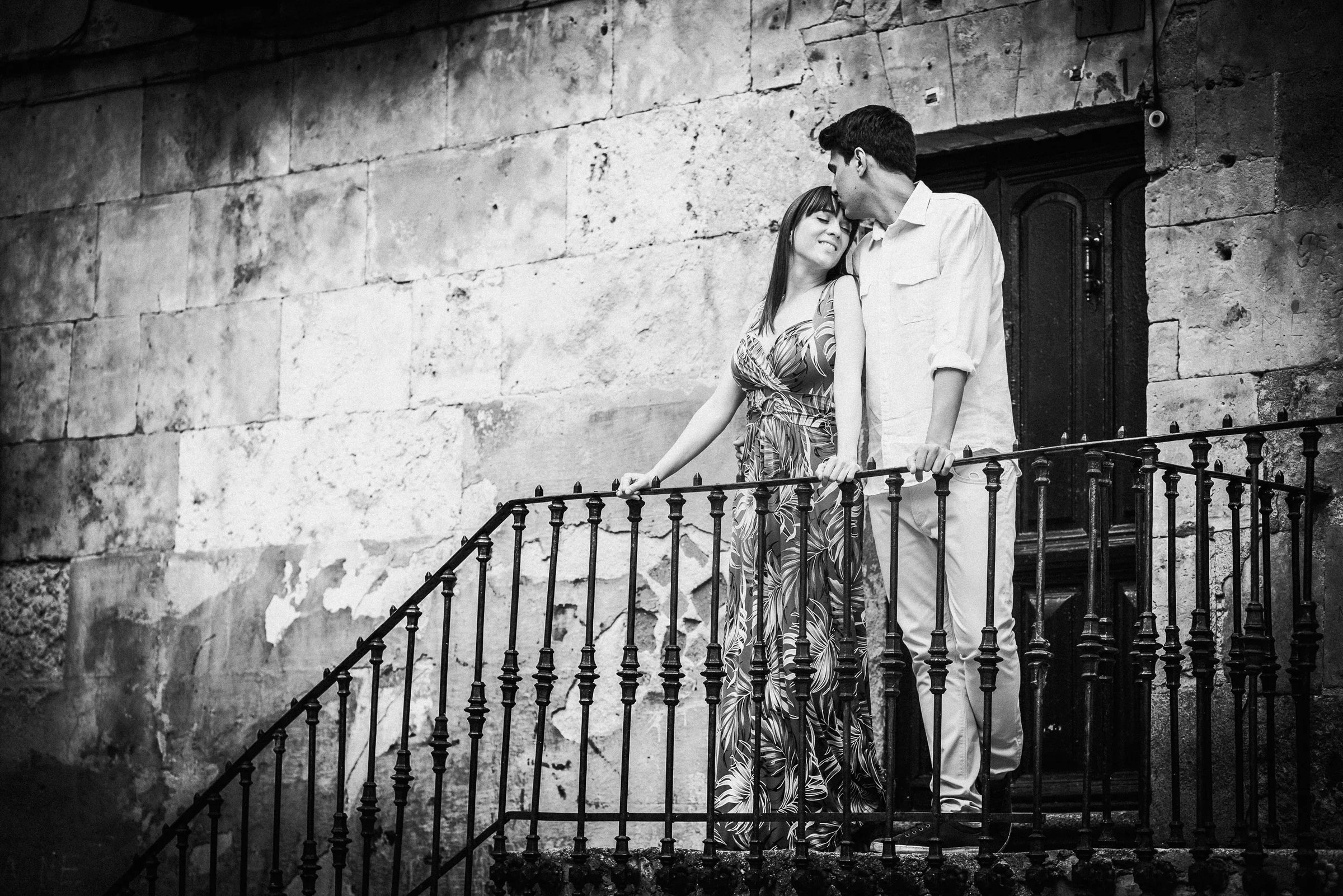 David y Noelia posan en blanco y negro junto a una escalera de piedra del centro histórico de Salamanca.