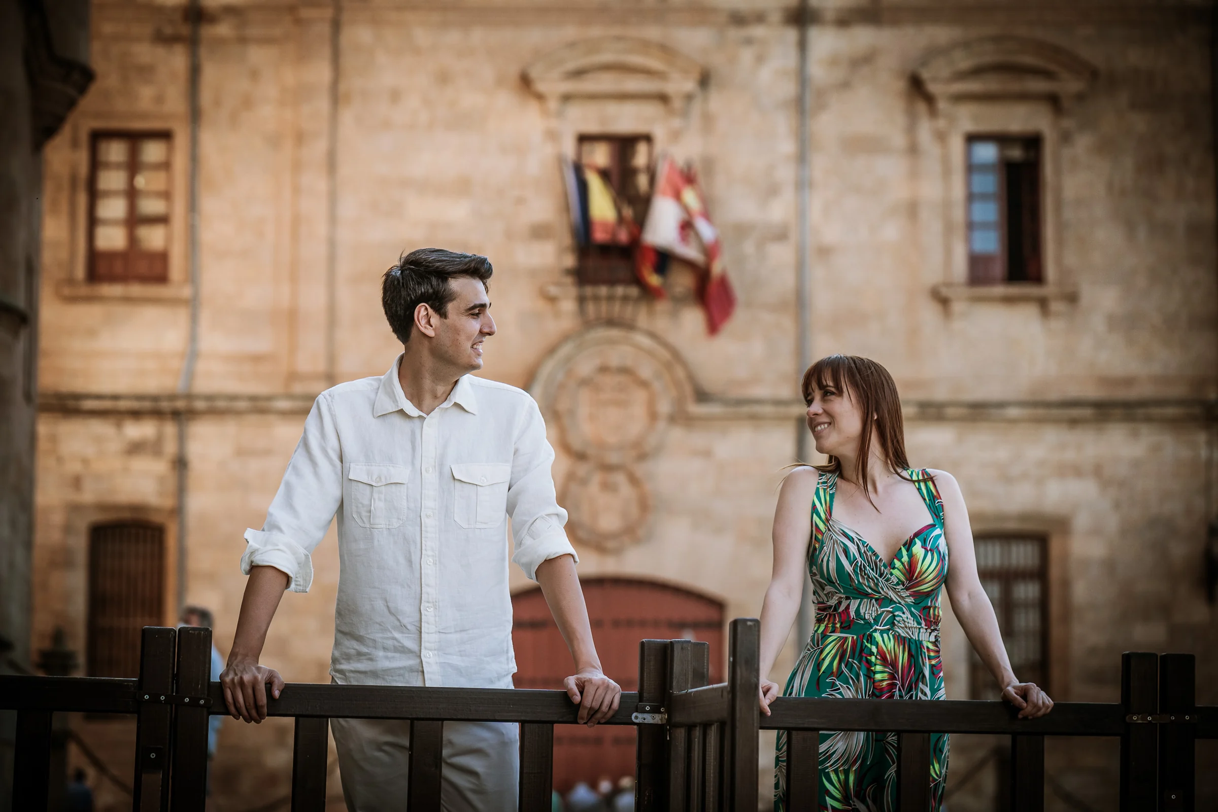 David y Noelia pasean frente a un edificio histórico del entorno universitario de Salamanca.