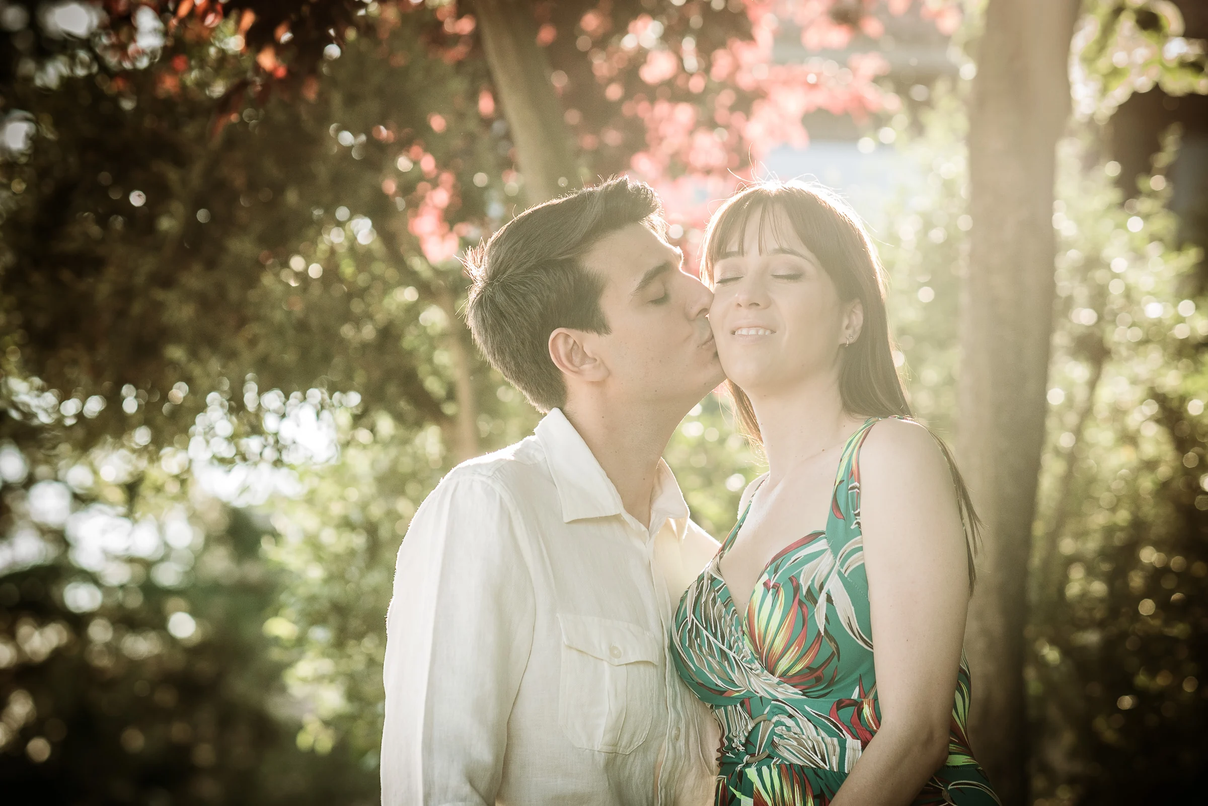 David y Noelia se abrazan a contraluz entre flores y vegetación durante su preboda en Salamanca.