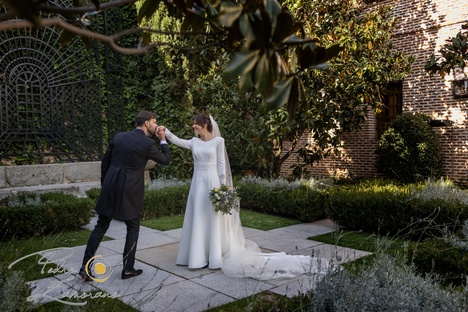 Novio besando la mano de la novia en los jardines de El Antiguo Convento.