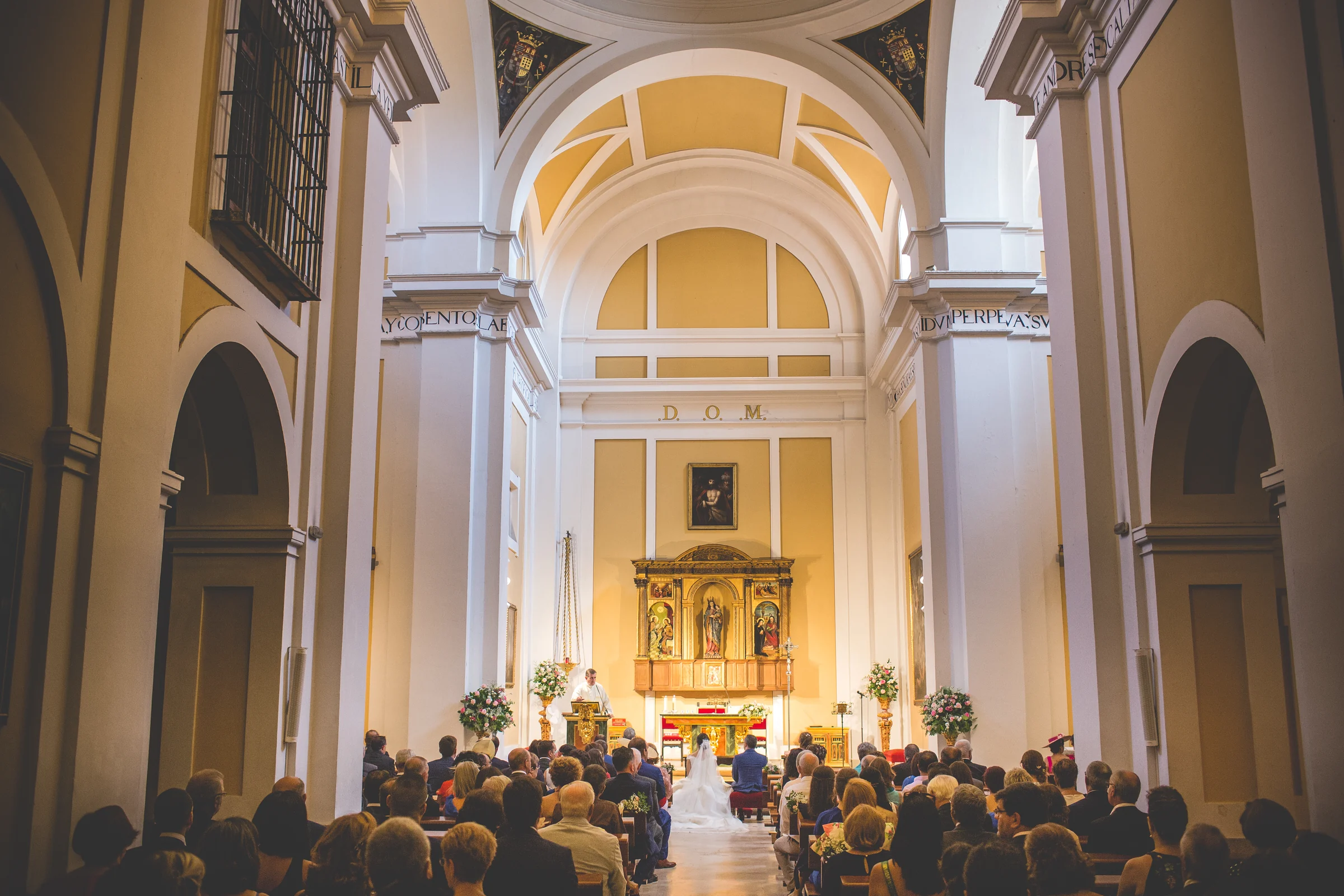 Vista general de una ceremonia religiosa con los novios frente al altar.