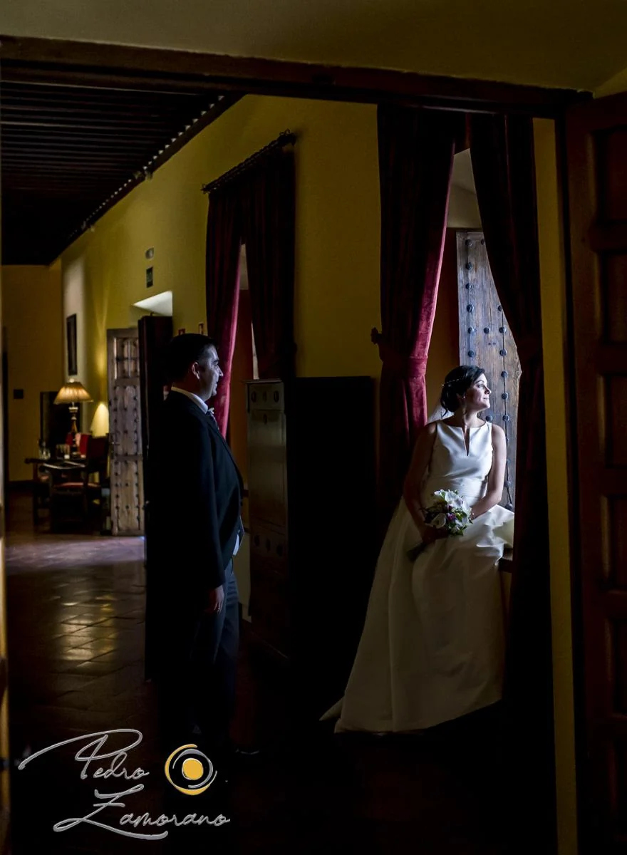 Novia enmarcada por una puerta interior antes de la ceremonia.