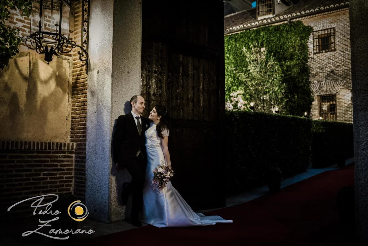 Pareja de novios posando junto a una puerta de ladrillo de El Antiguo Convento de Boadilla del Monte.