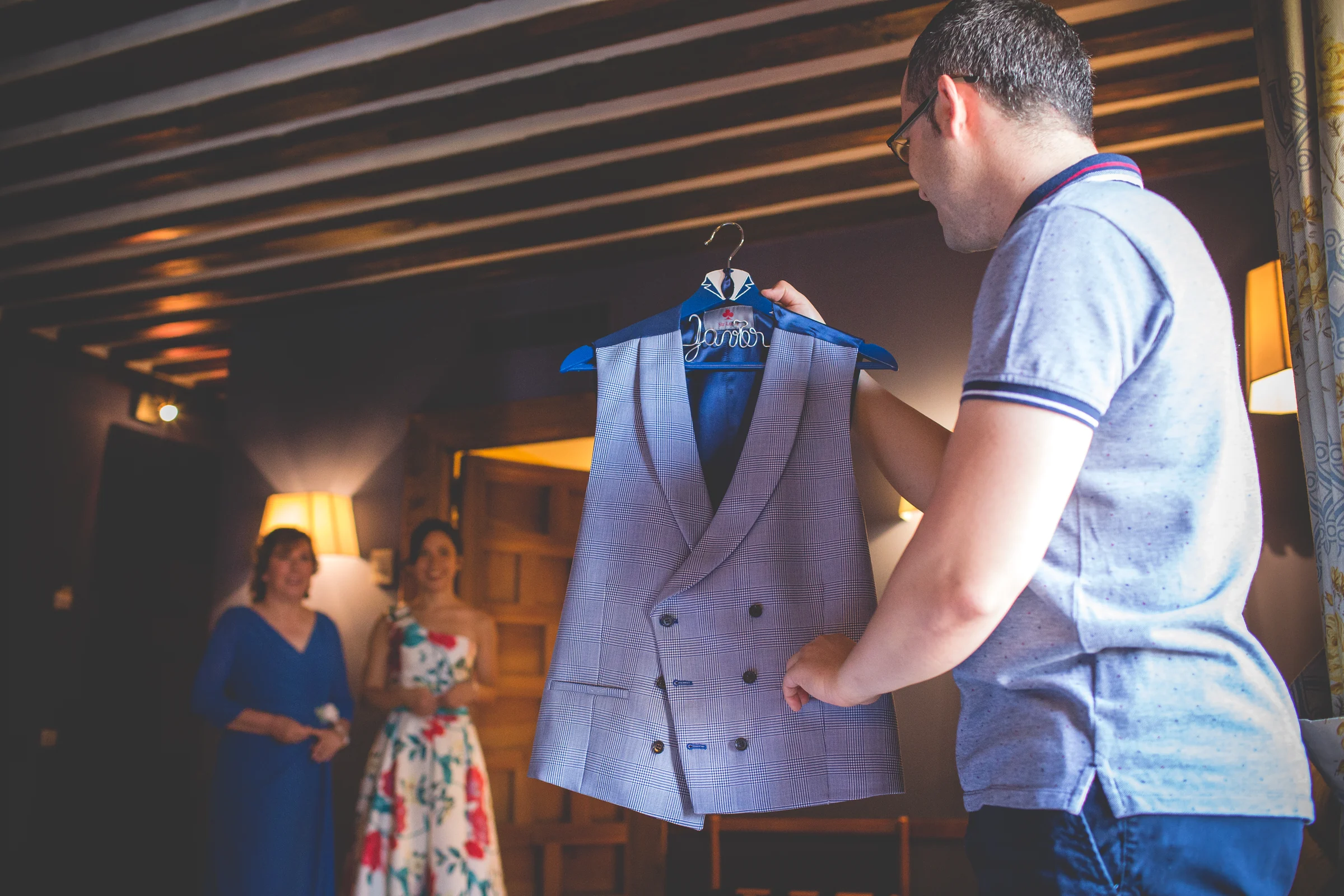Hombre sosteniendo el traje del novio durante los preparativos de boda.