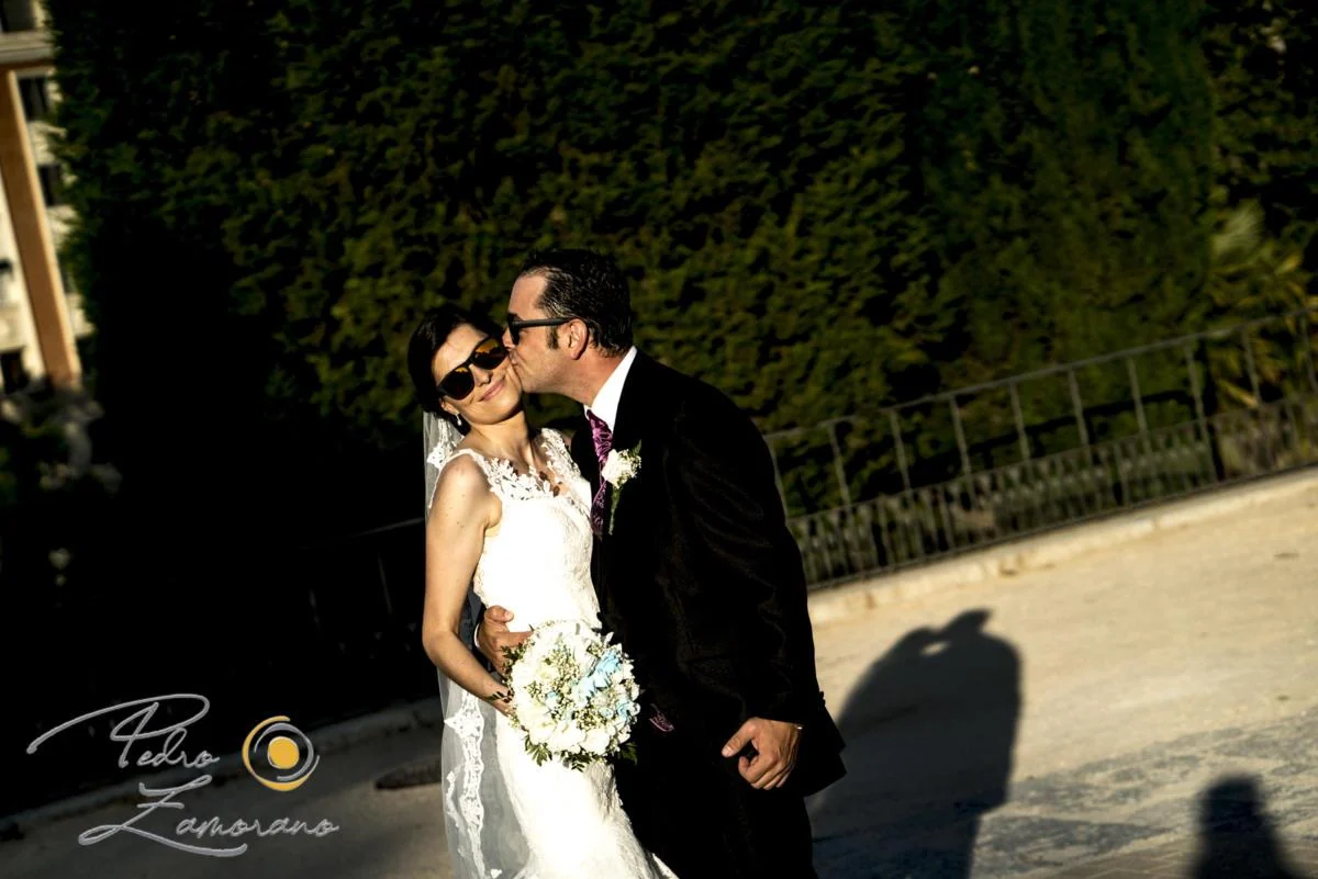 Beso de los novios con luz de tarde en Finca La Alquería