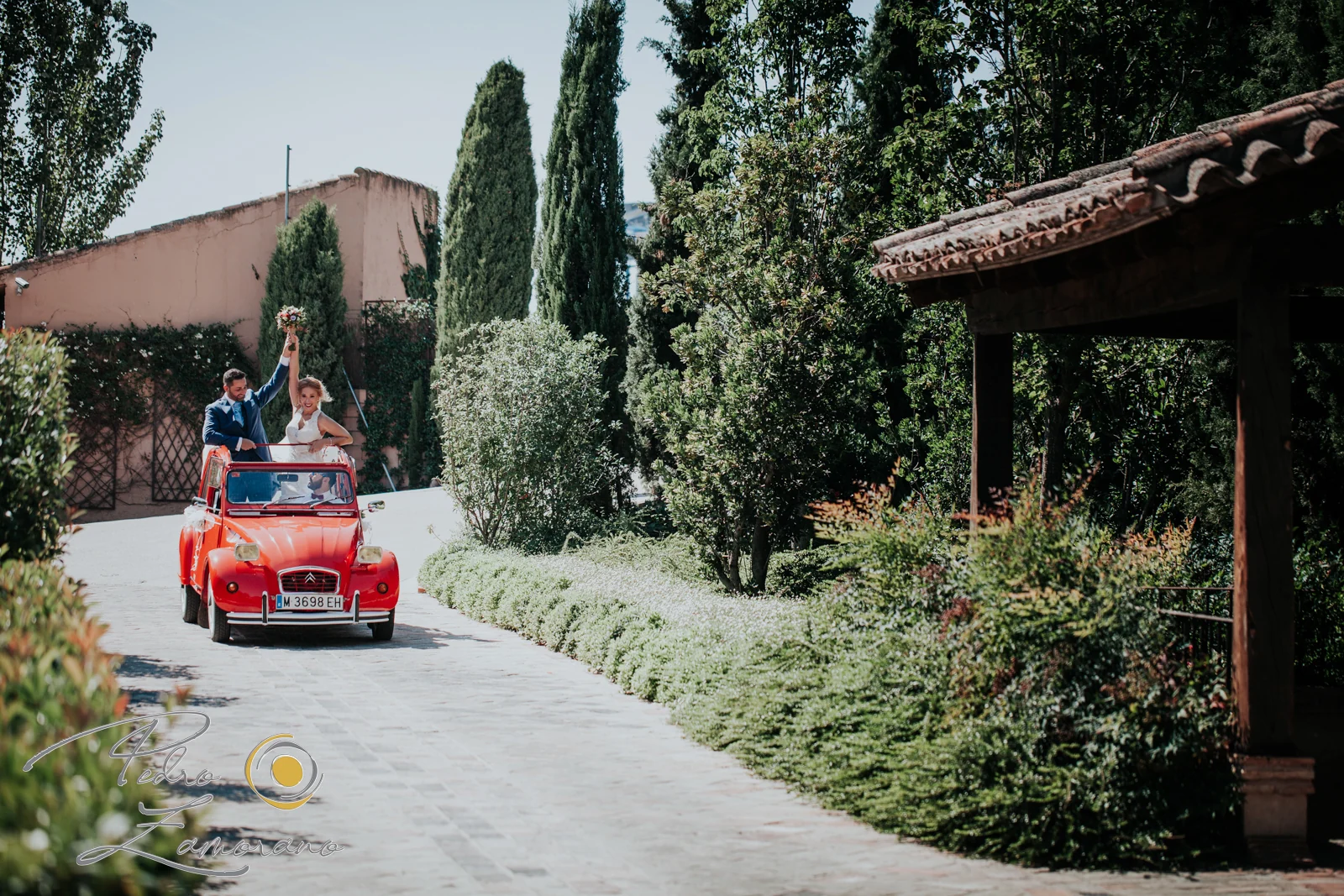 Novios llegando en coche rojo a Finca La Alquería
