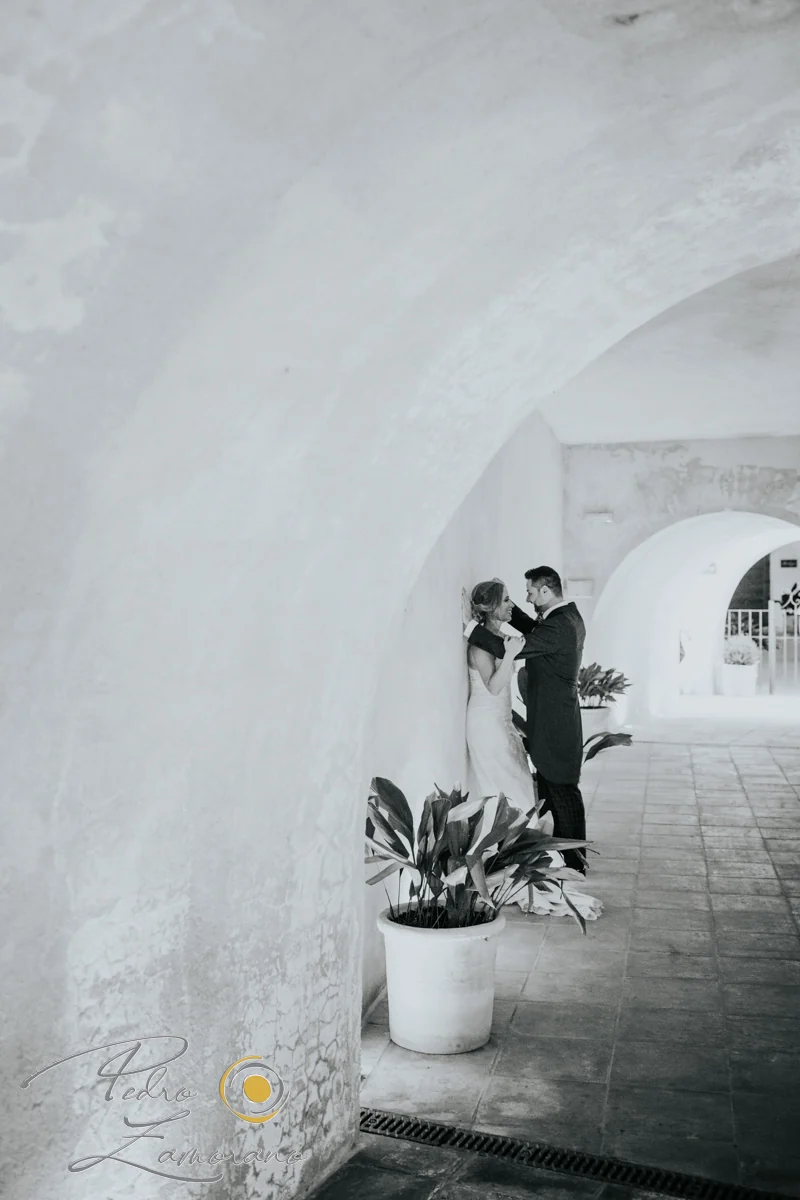 Novios en un pasillo de arcos en blanco y negro en Finca La Alquería