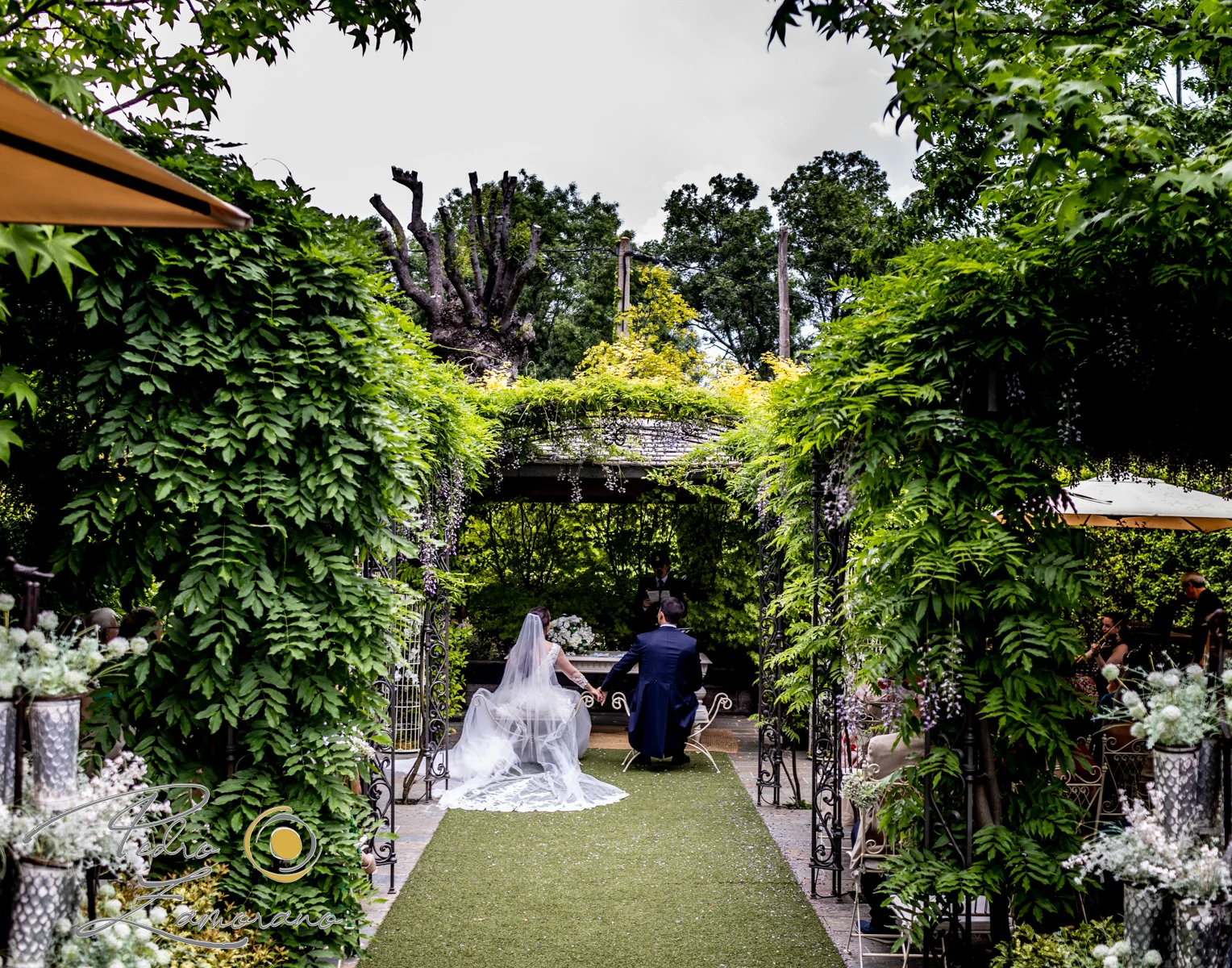 Ceremonia de boda al aire libre bajo la pérgola vegetal de Hacienda Jacaranda.