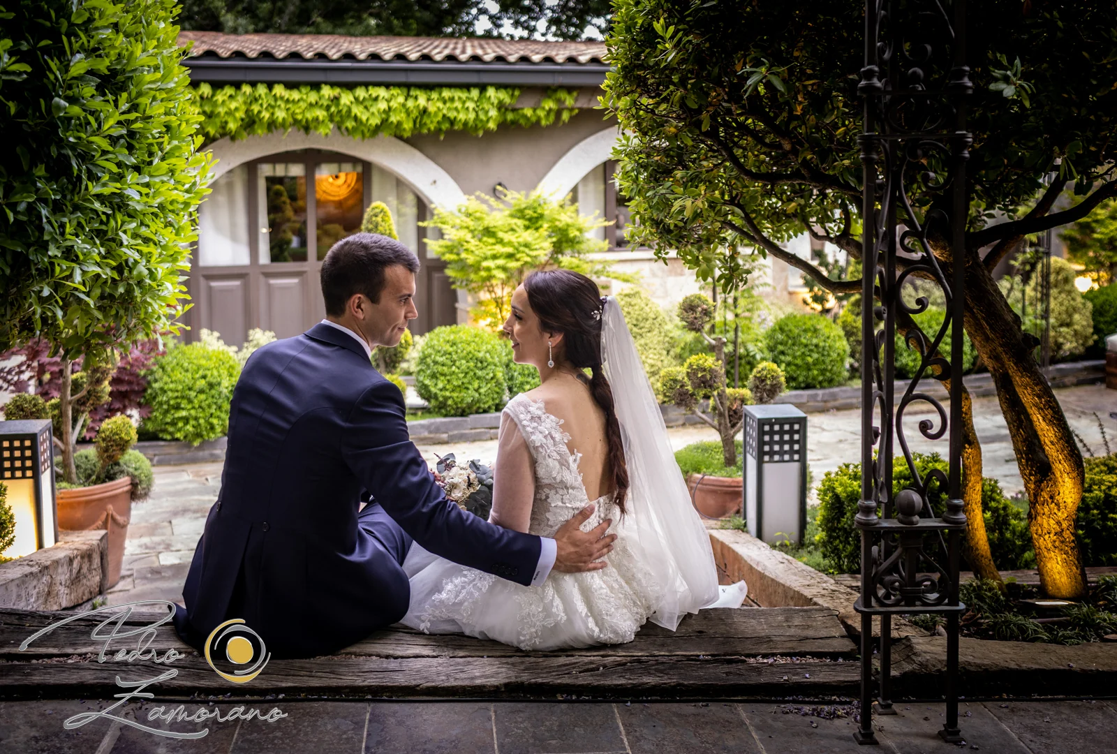 Pareja sentada en unos escalones del jardín de Hacienda Jacaranda.