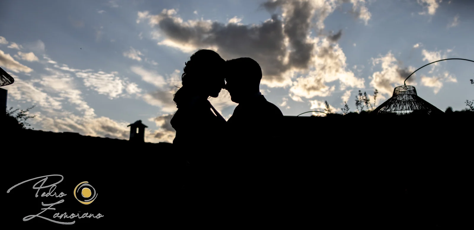 Silueta de una pareja de novios frente a un cielo de atardecer en Hacienda Jacaranda.